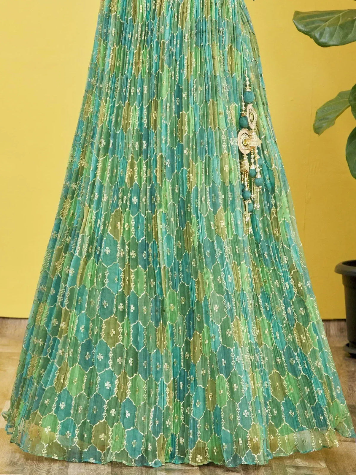 Green and teal pleated ethnic skirt with geometric embroidery and tassel details
