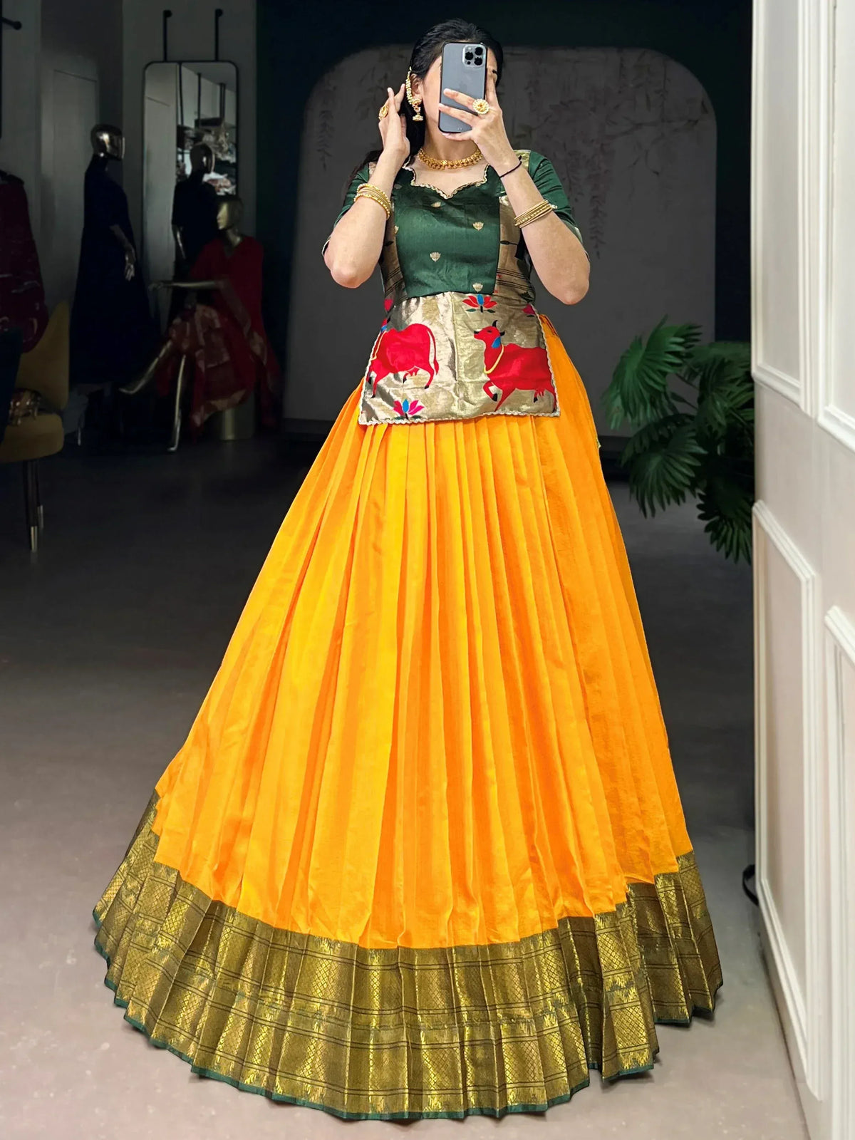 Vibrant orange and green ethnic lehenga with embroidered cow motifs, perfect for festive occasions.