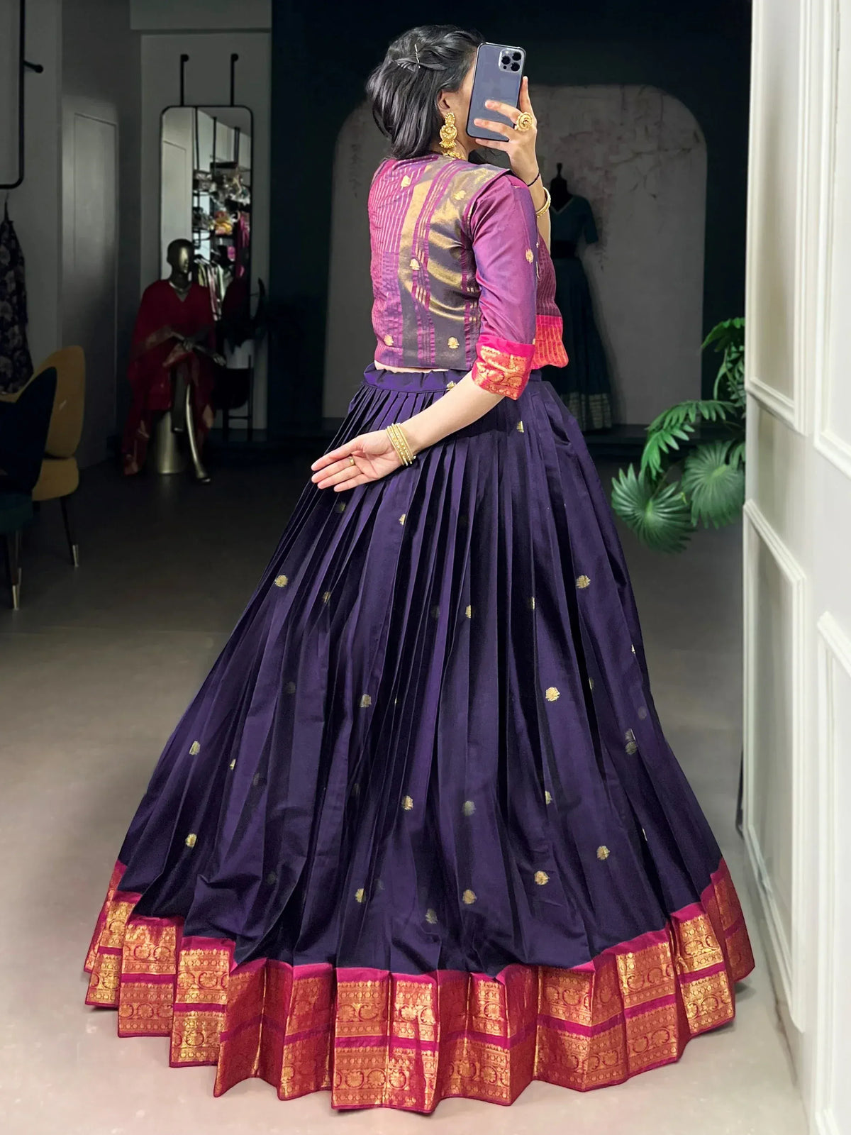 Purple pleated lehenga with gold motifs and red-gold border, paired with patterned blouse, perfect for Indian ethnic occasions.