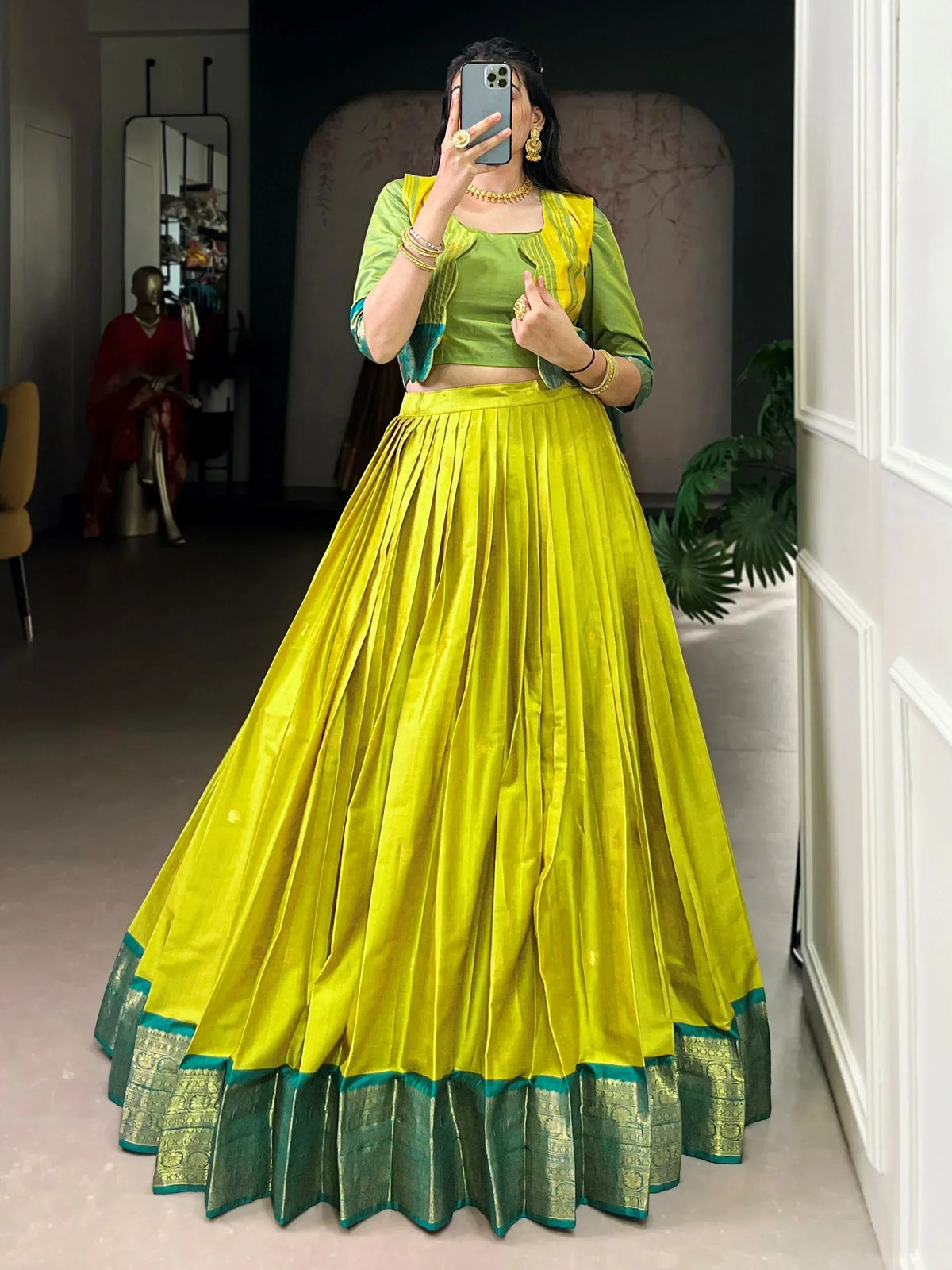 Vibrant yellow-green lehenga choli with pleated skirt and gold jewelry for Indian ethnic wear