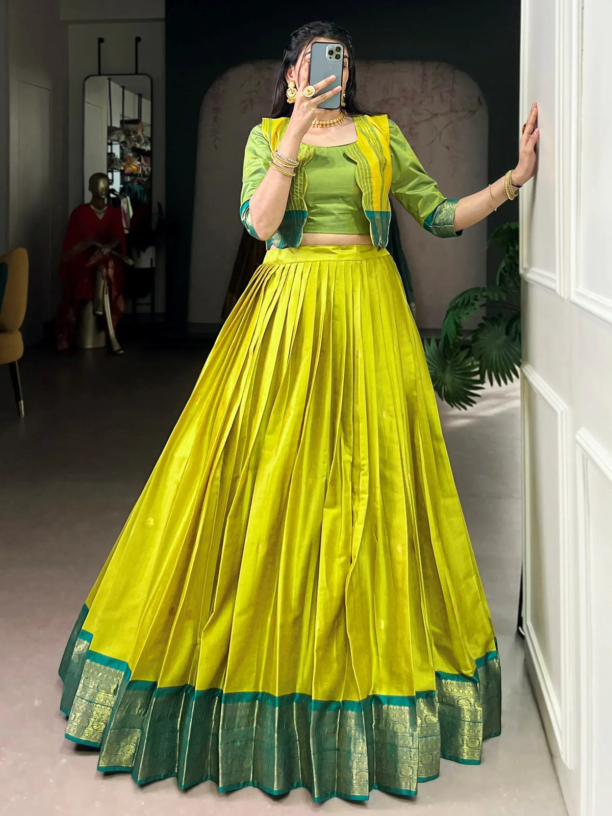 Vibrant yellow and green ethnic lehenga choli with pleated skirt and embroidered border, perfect for festive occasions.