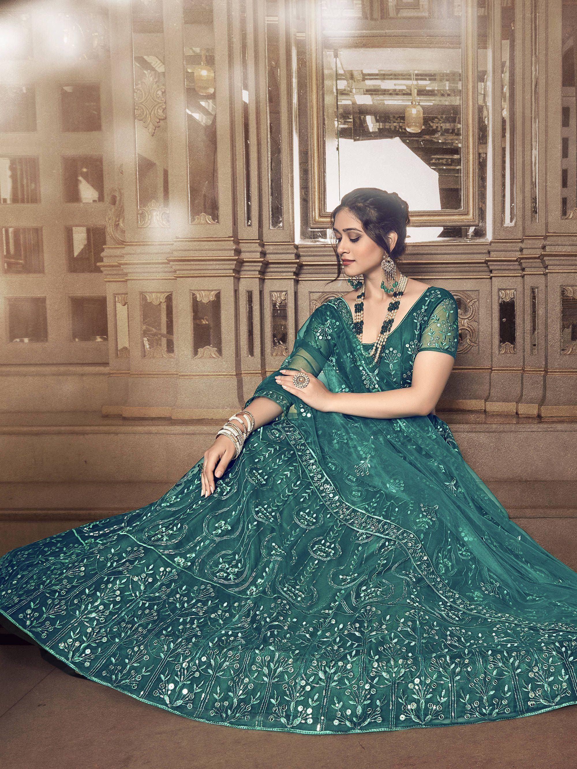Elegant green embroidered lehenga choli with intricate designs and traditional jewelry
