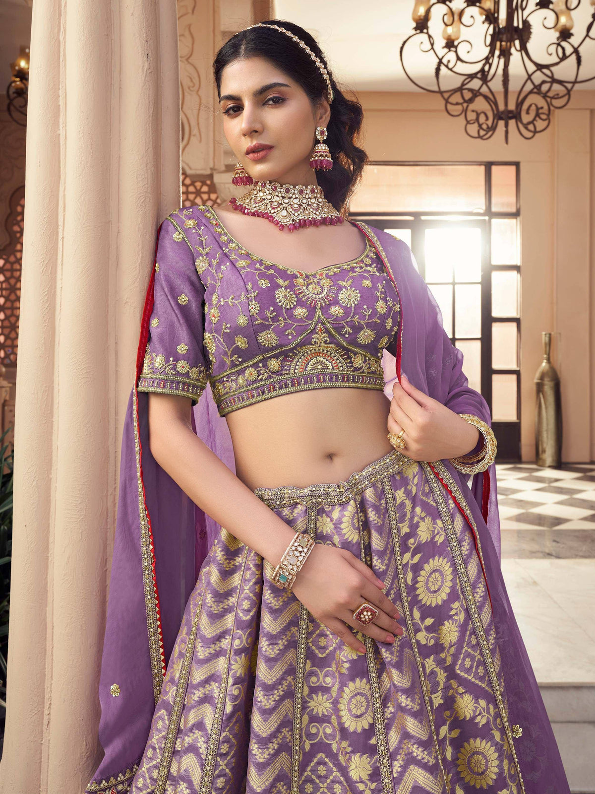Purple embroidered lehenga choli with gold detailing and matching jewelry