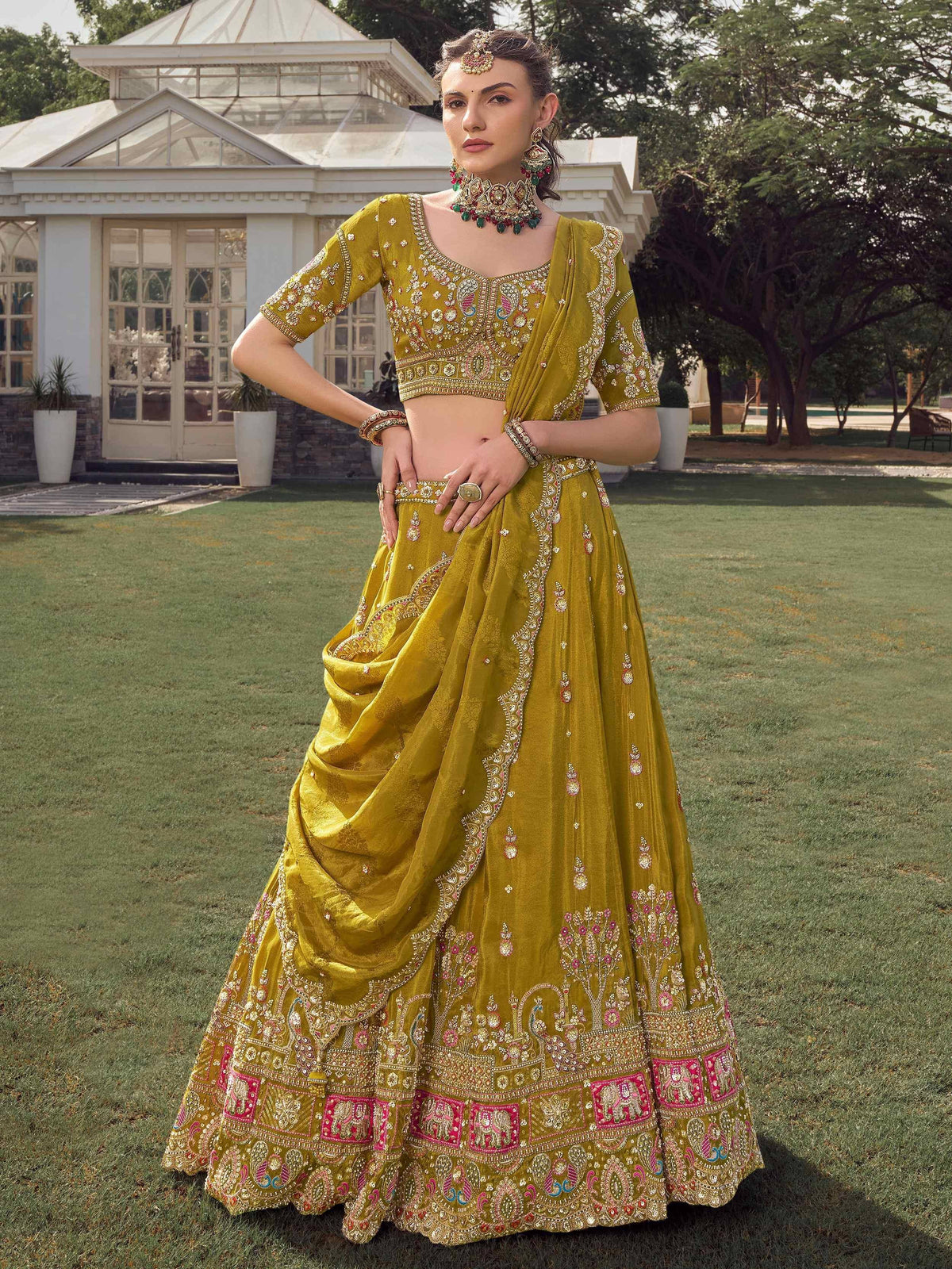 Elegant mustard yellow lehenga choli with intricate embroidery and pink accents, perfect for Indian ethnic wear.