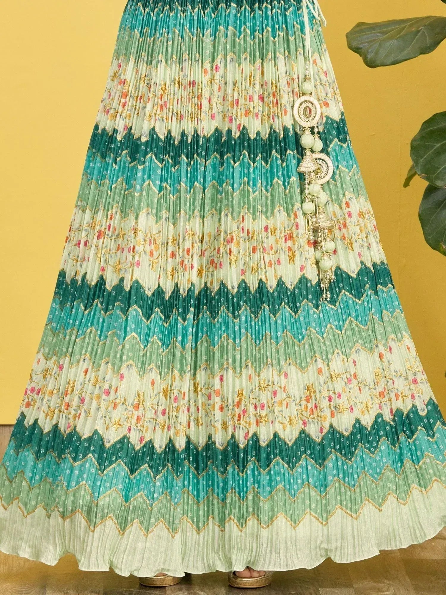 Teal and cream pleated lehenga skirt with floral embroidery and gold zigzag patterns, perfect for Indian ethnic wear.