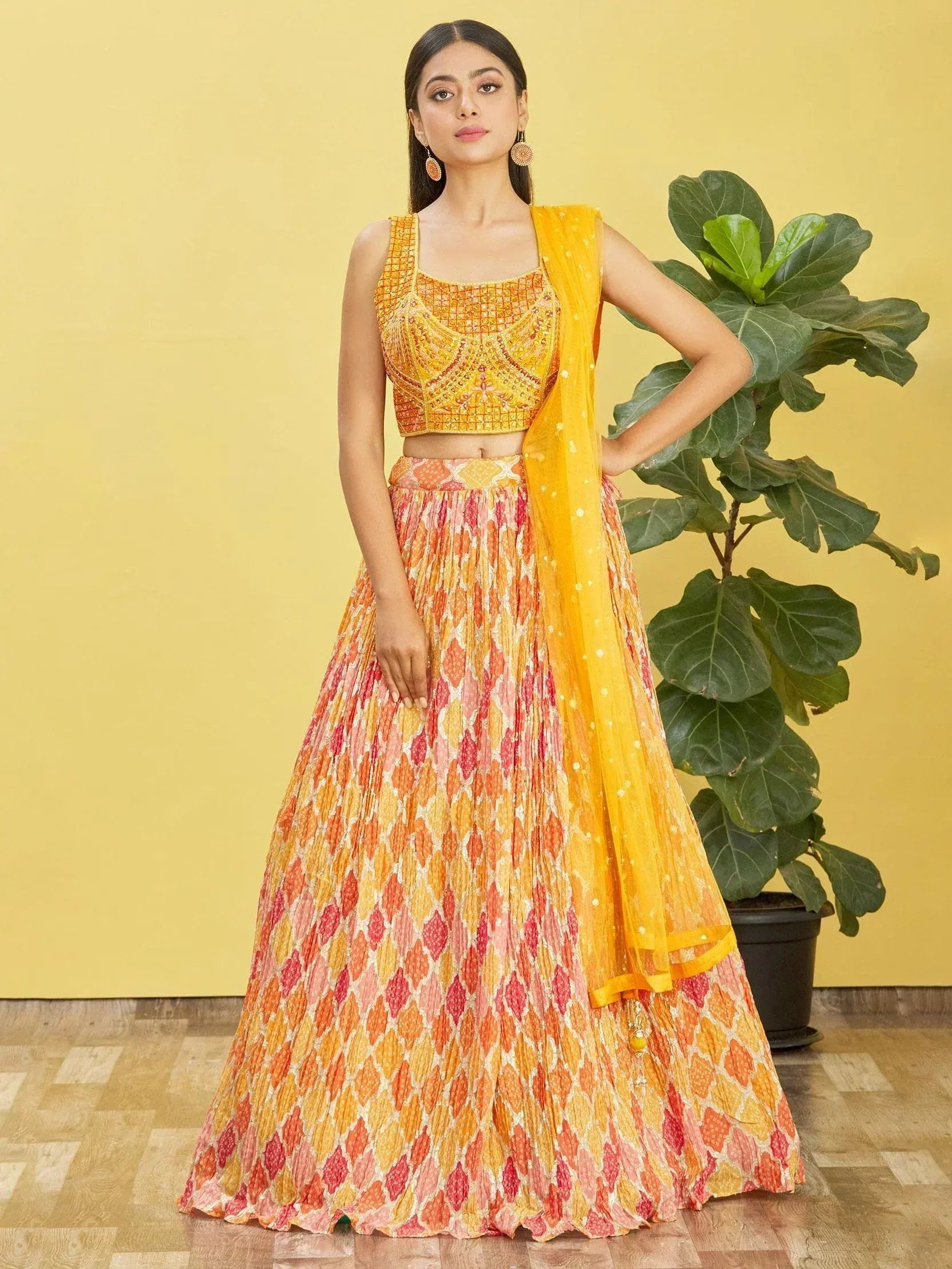 Yellow and orange printed lehenga choli with embroidered crop top and dupatta, ideal for Indian ethnic wear