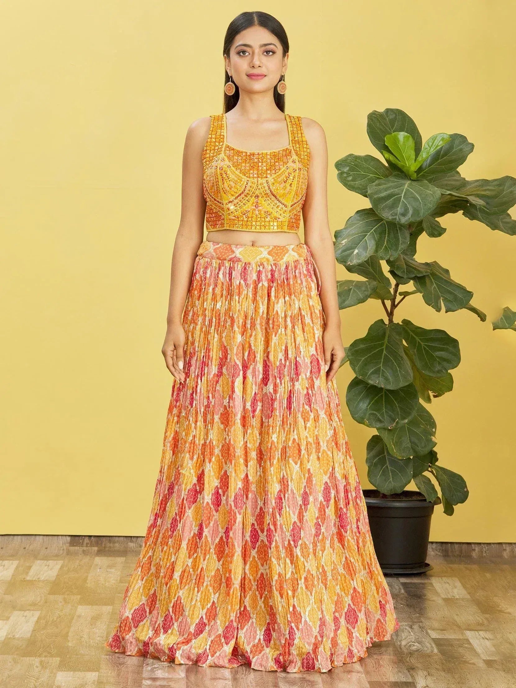 Women's vibrant orange and pink printed lehenga with embroidered crop top, perfect for Indian ethnic occasions