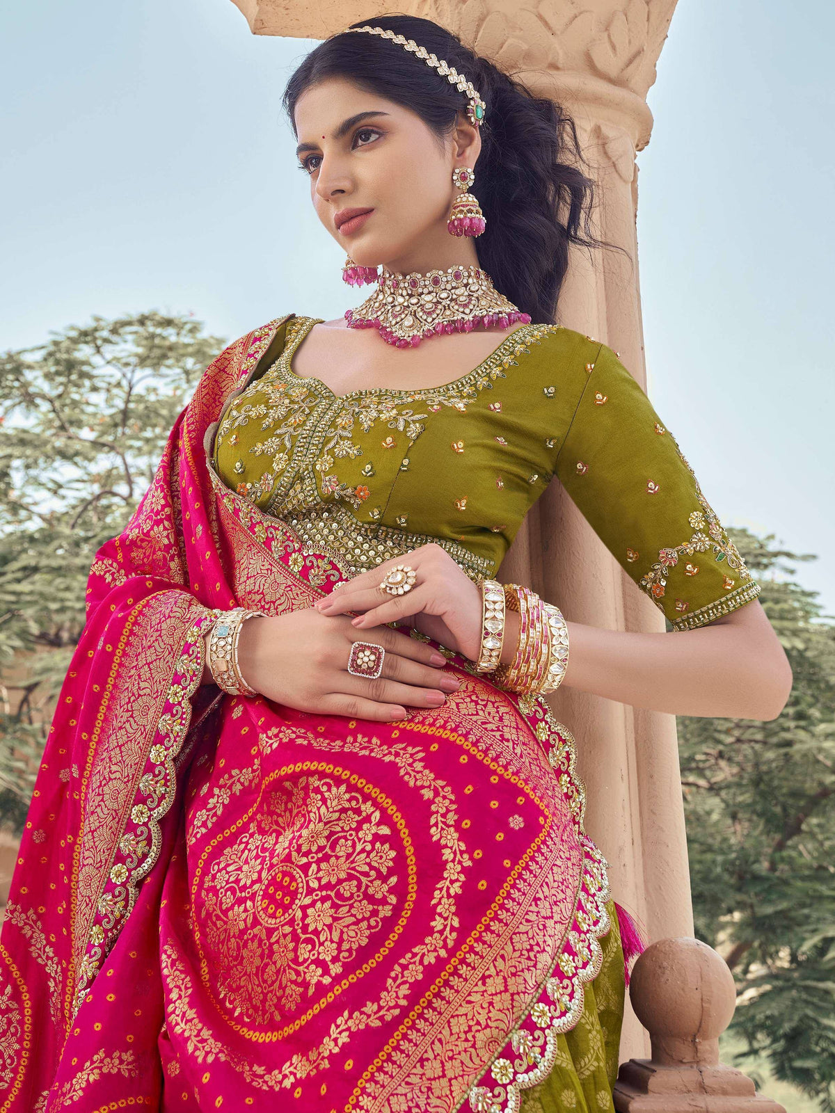 Elegant Indian ethnic wear: olive green embroidered blouse with vibrant pink lehenga, perfect for weddings and festivals.