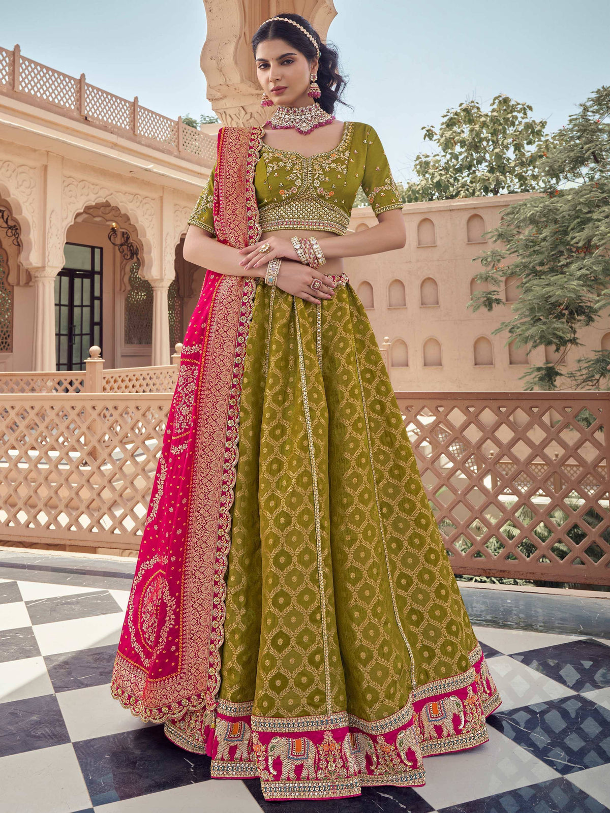 Olive green and pink embroidered lehenga choli with elephant motifs, perfect for Indian weddings and festivals.