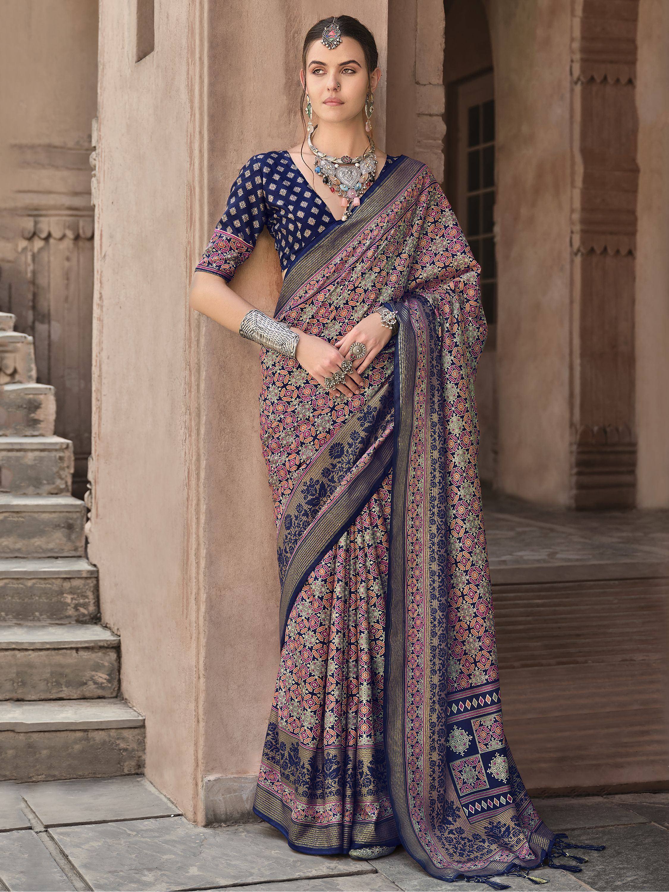 Woman in navy blue printed saree with ethnic jewelry, traditional Indian attire for festive occasions