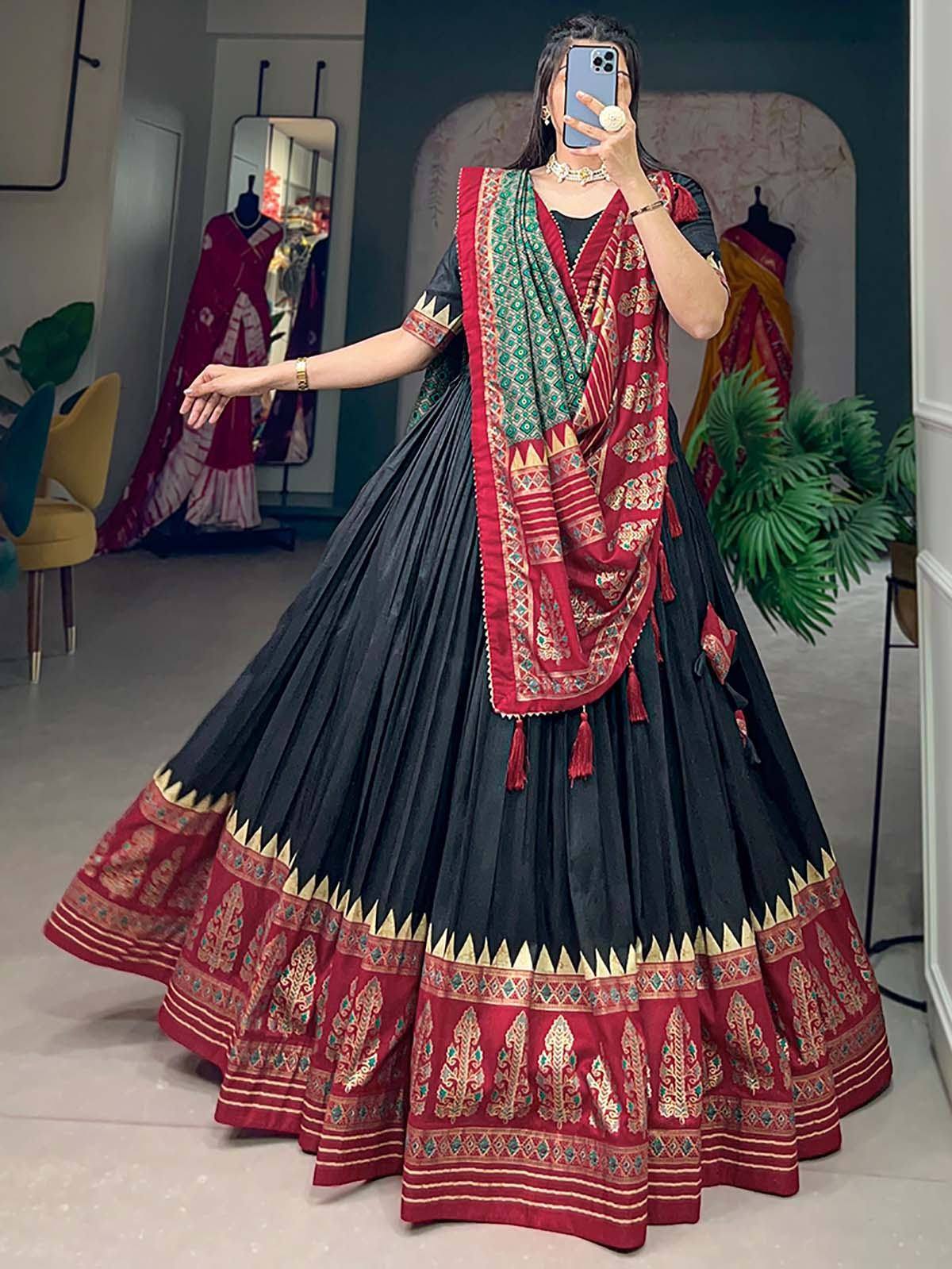 Black and red ethnic lehenga choli with intricate gold embroidery and pleated skirt, perfect for Indian weddings or festive occasions.