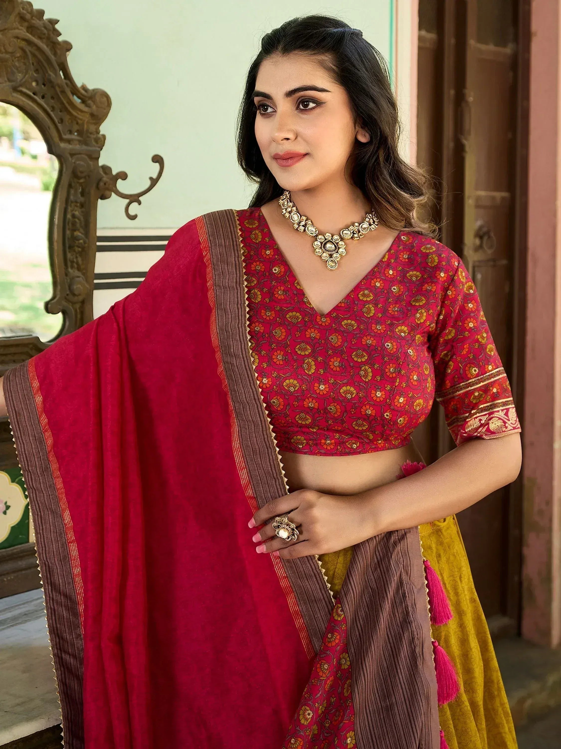 Woman in red floral blouse with maroon dupatta, ethnic Indian wear, traditional jewelry