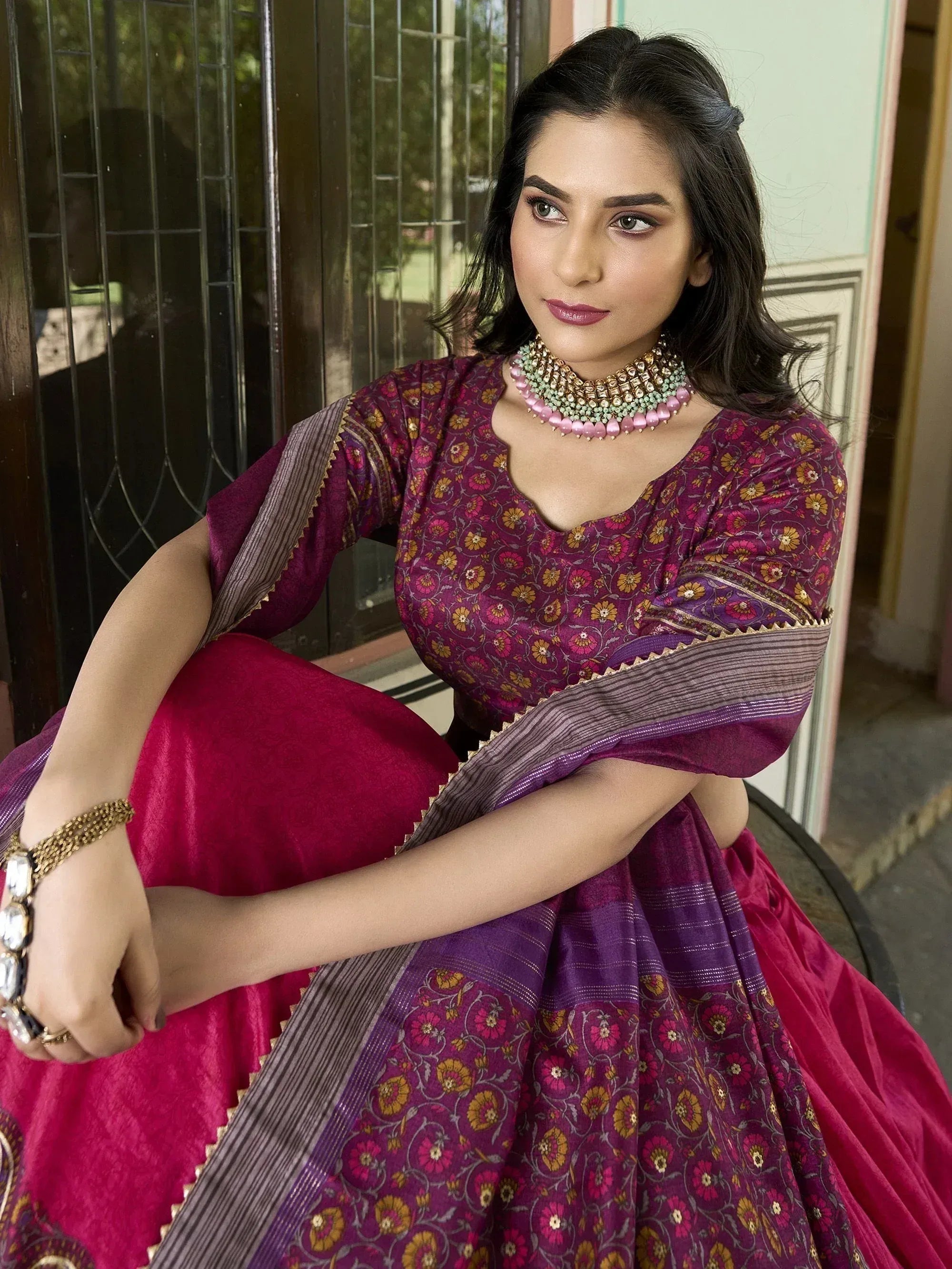 Woman in purple floral lehenga choli with gold embroidery, styled with statement necklace for Indian ethnic wear