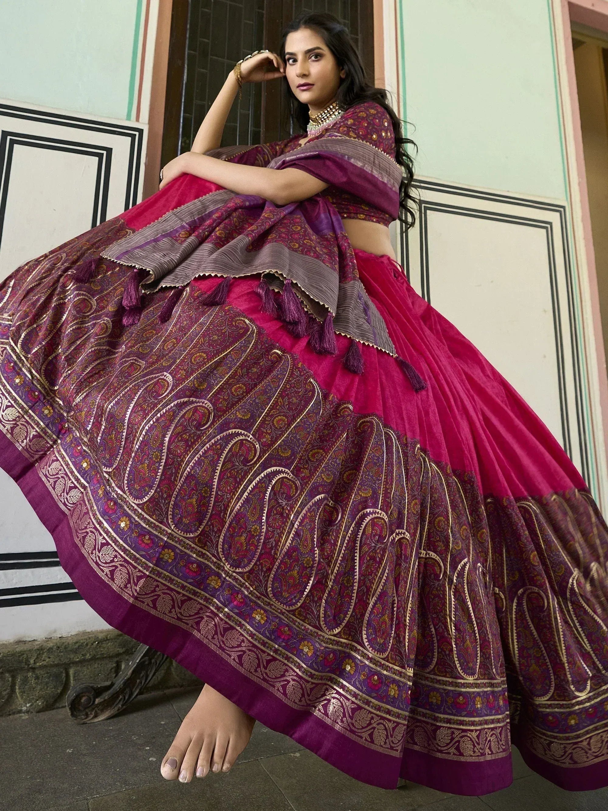 Woman in purple and pink designer lehenga choli with paisley print, perfect for Indian ethnic wear occasions