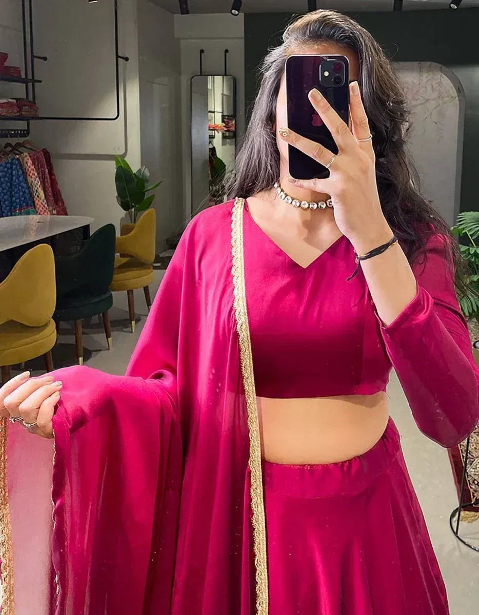 Vibrant pink velvet lehenga choli with gold trim, perfect for Indian ethnic wear and festive occasions.