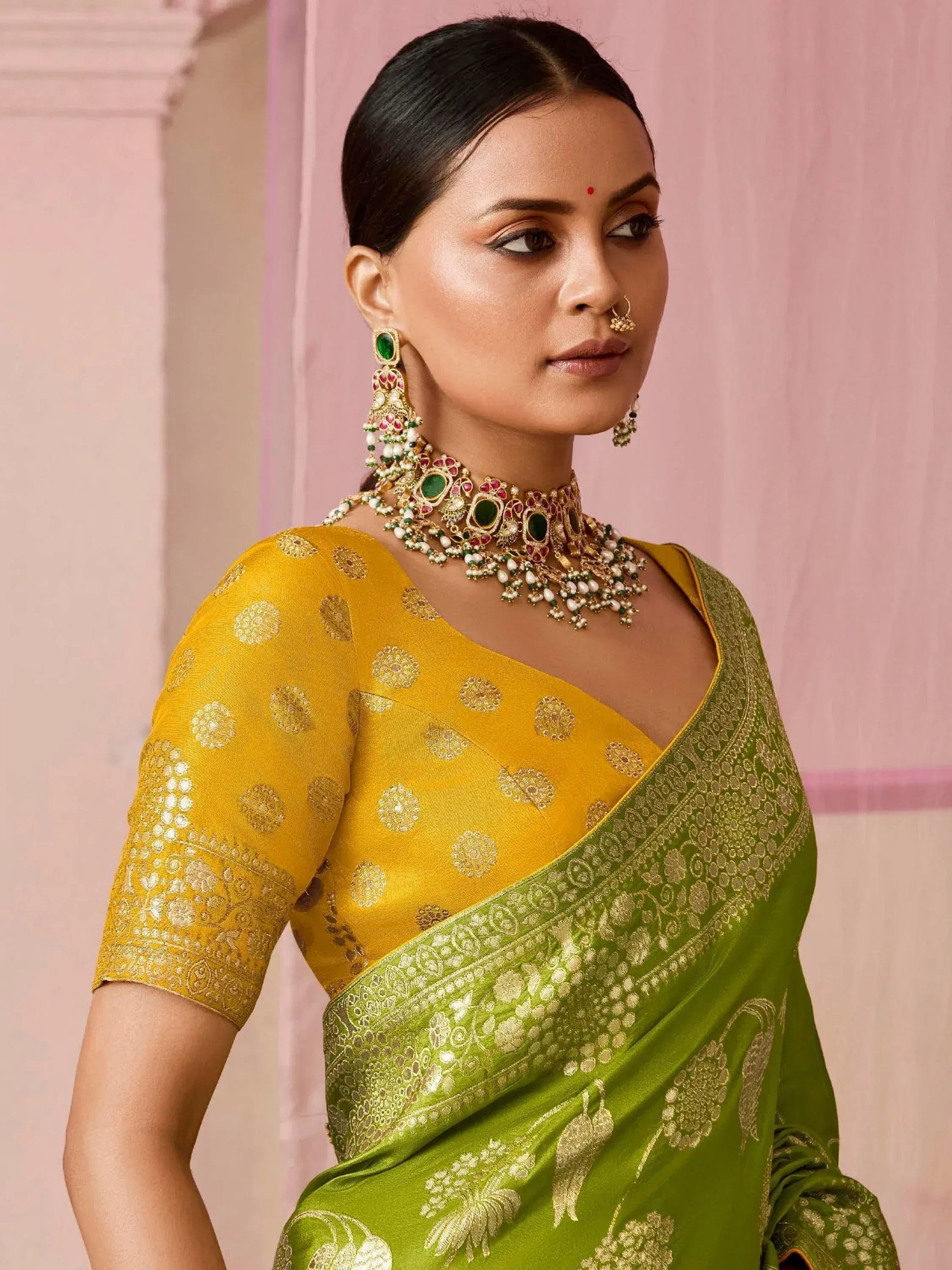 Yellow and green designer saree with gold embroidery, paired with traditional Indian jewelry for ethnic wear.