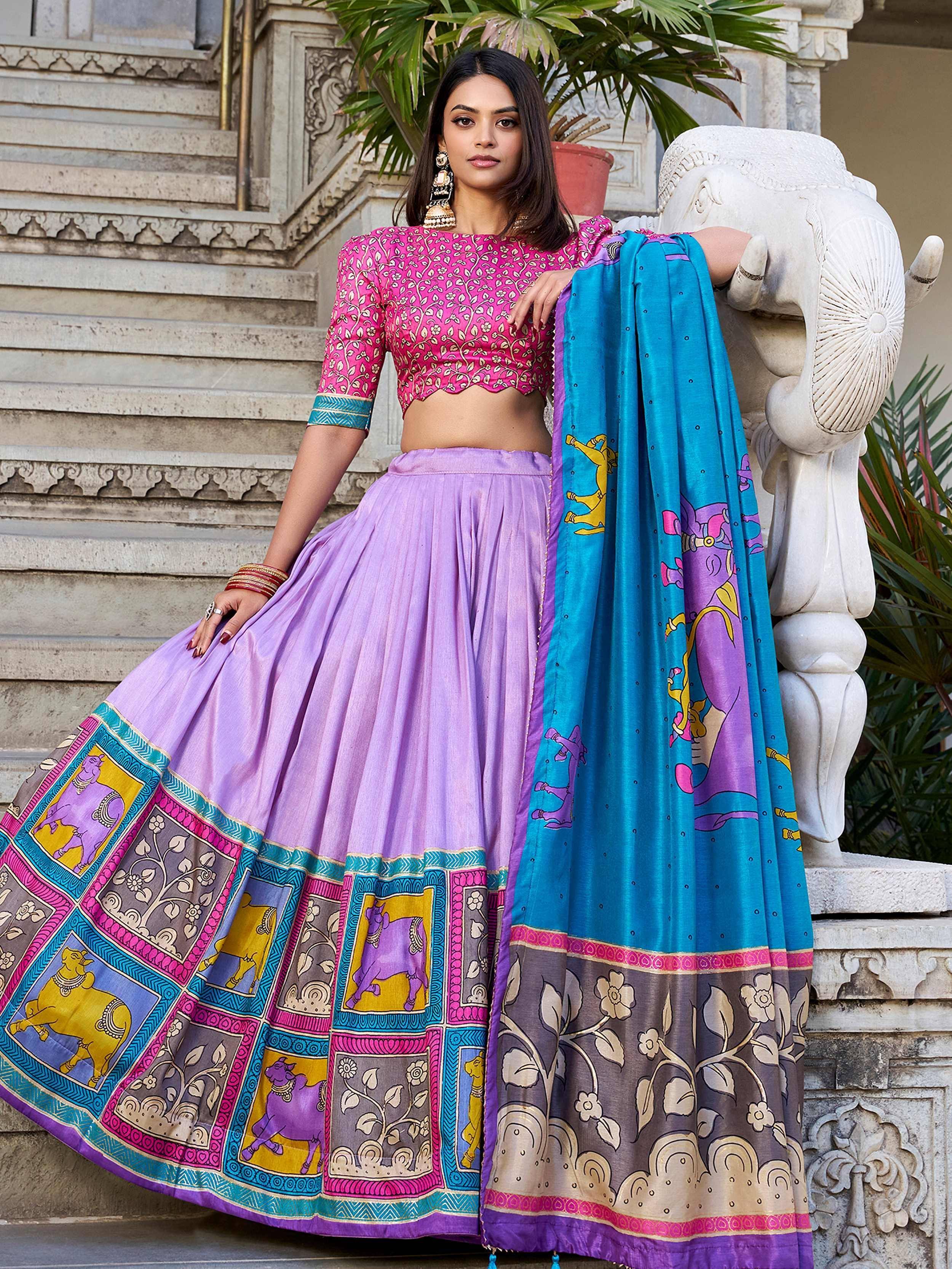 Woman in vibrant pink and purple printed lehenga choli with blue dupatta, traditional Indian ethnic wear