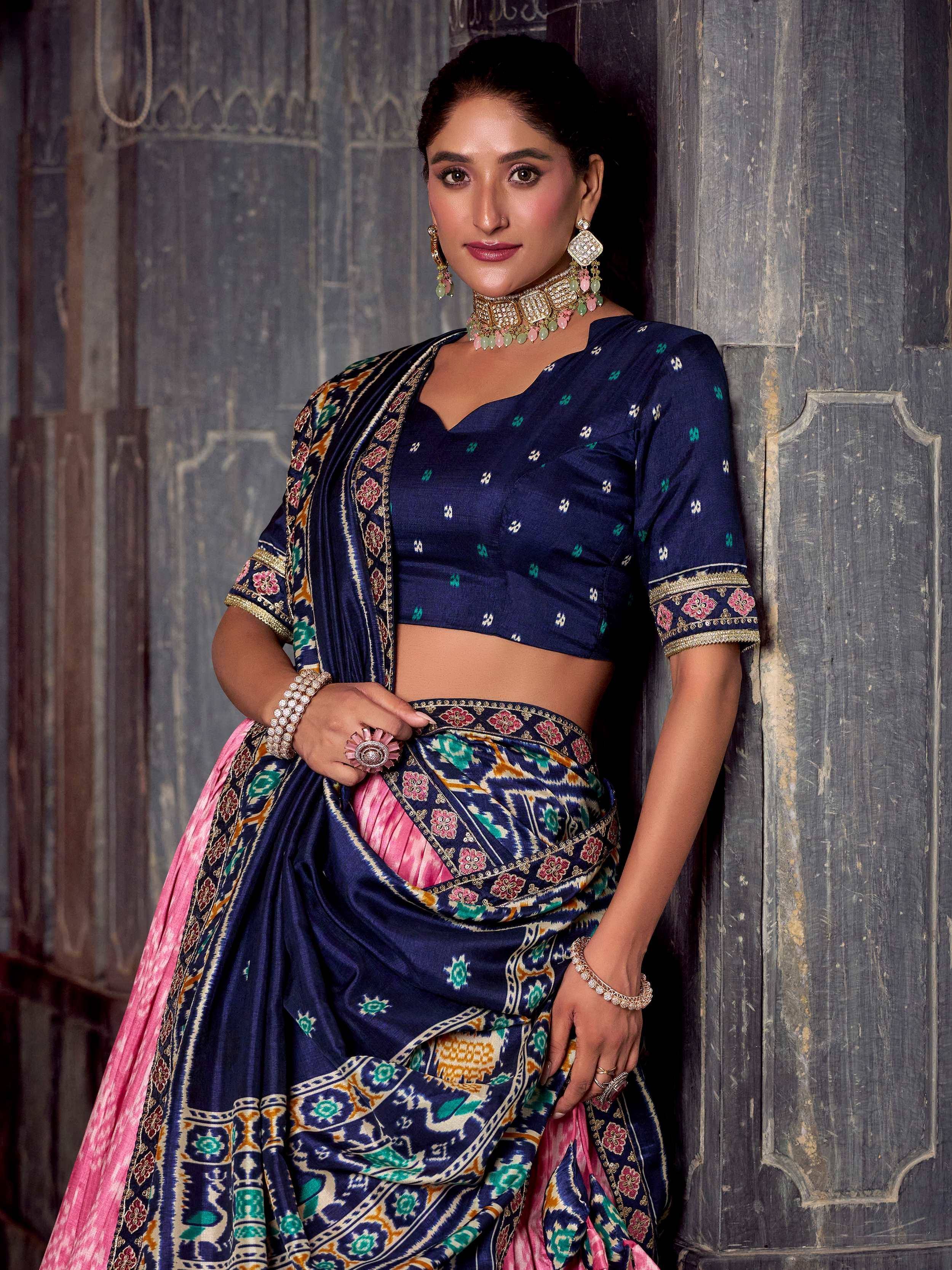Woman in navy blue designer lehenga choli with pink ikat print, perfect for Indian ethnic wear occasions