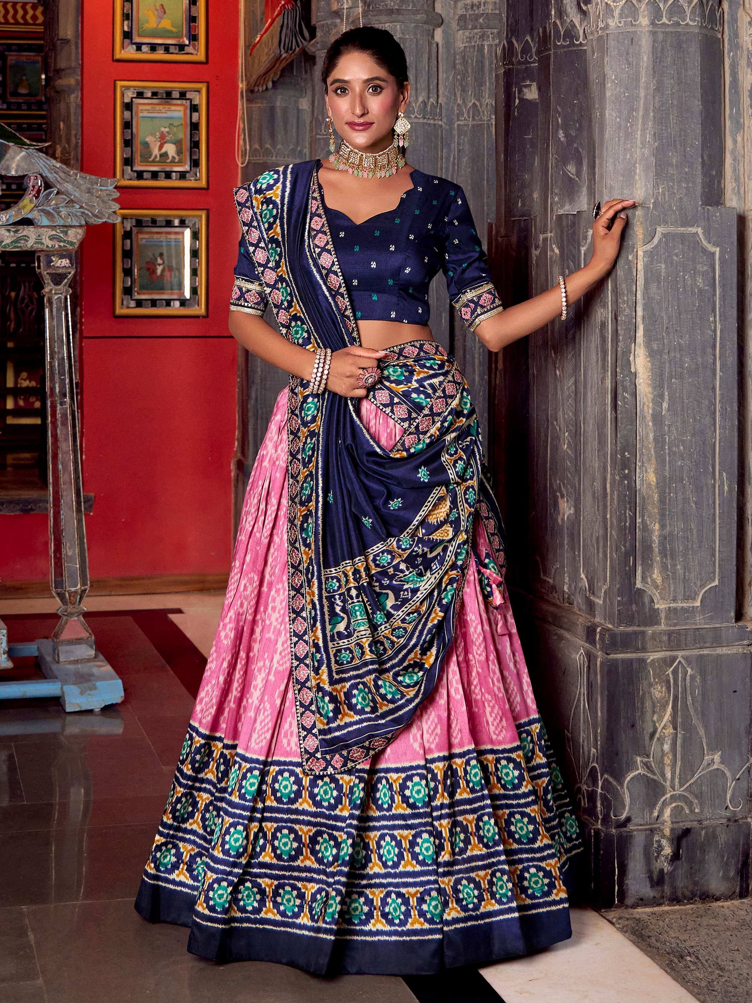 Woman in navy and pink designer lehenga choli with floral embroidery, perfect for Indian ethnic wear occasions.