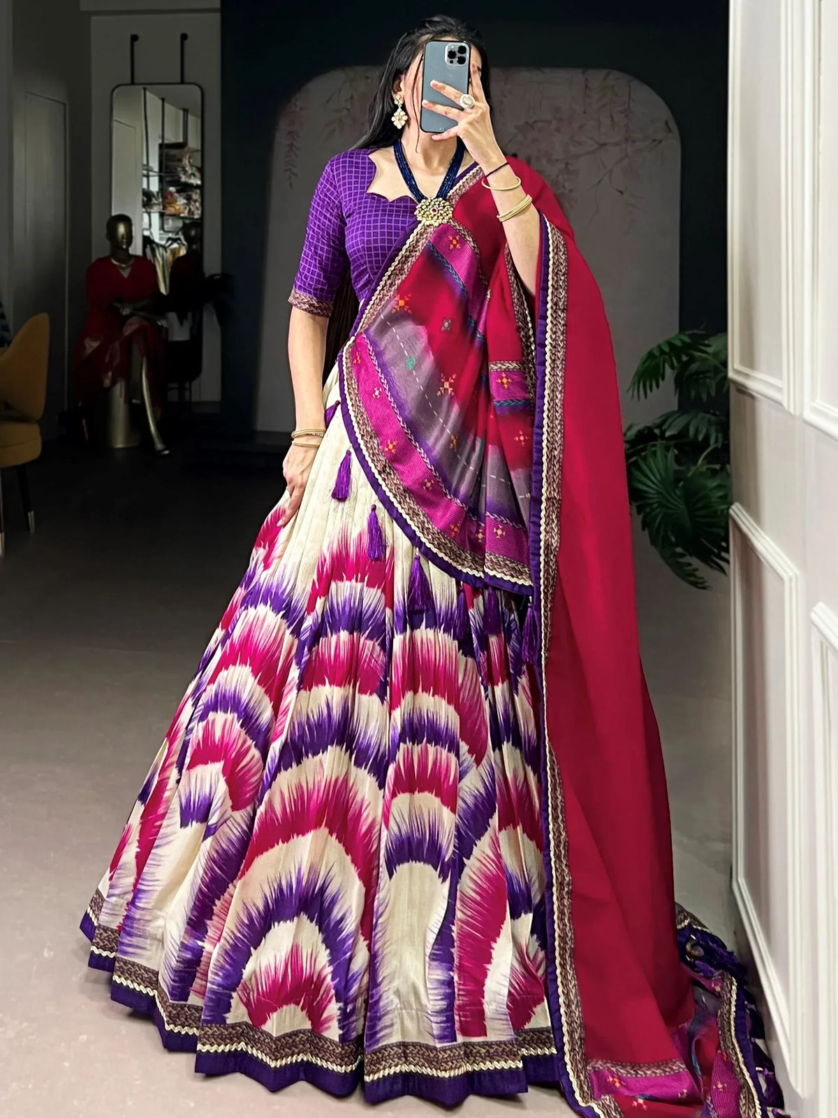 Vibrant purple and pink ikat print lehenga choli with embroidered dupatta, perfect for Indian ethnic wear occasions.