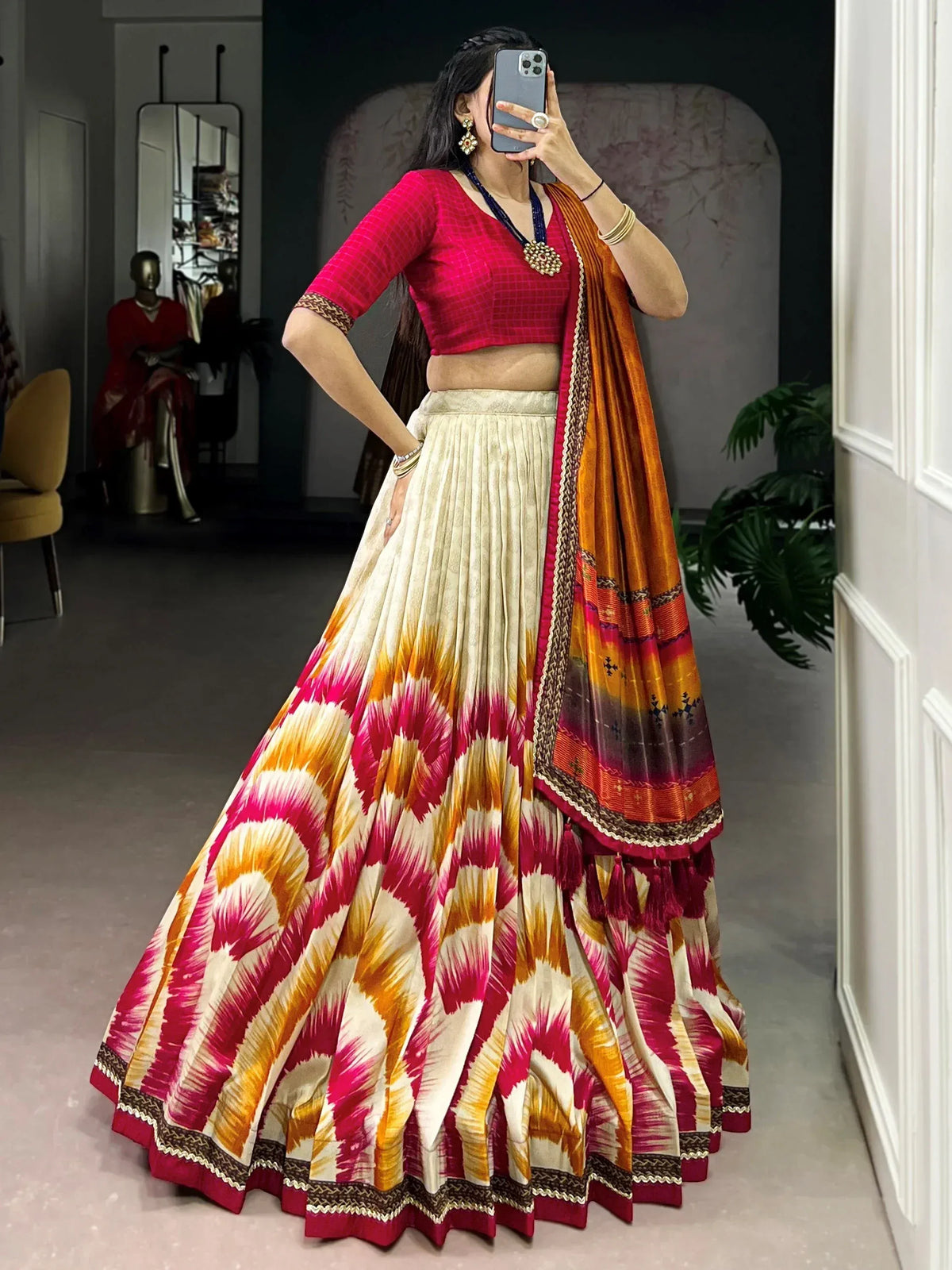 Vibrant pink and gold ikat print lehenga choli with pleated skirt and matching dupatta, perfect for Indian ethnic wear.