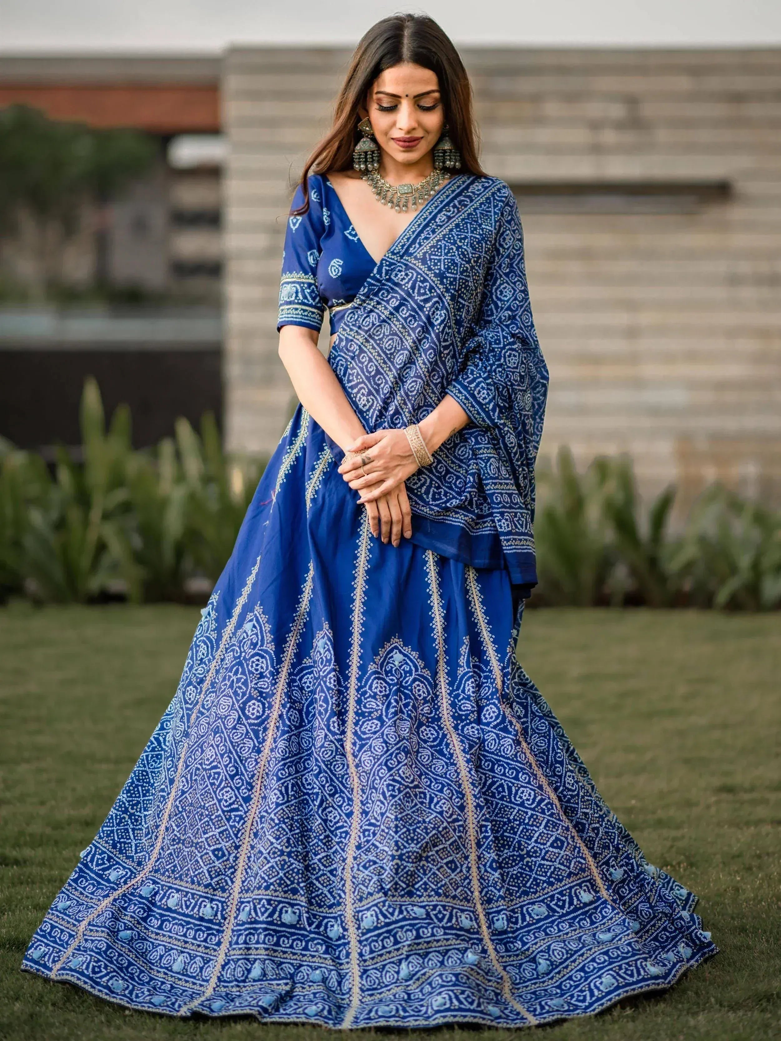Blue printed lehenga choli with ethnic jewelry, perfect for Indian weddings and festive occasions.