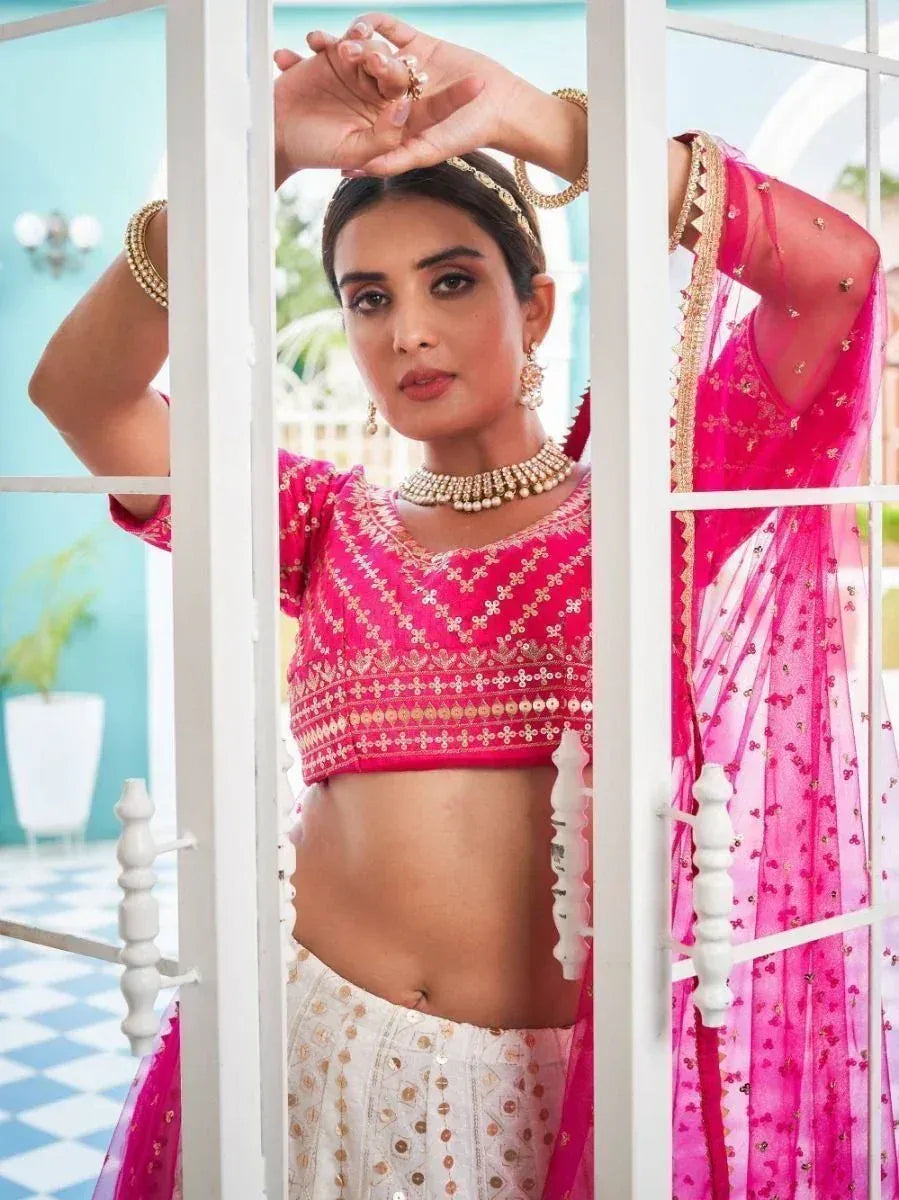 Pink embroidered lehenga choli with gold detailing, styled with traditional jewelry for ethnic wear