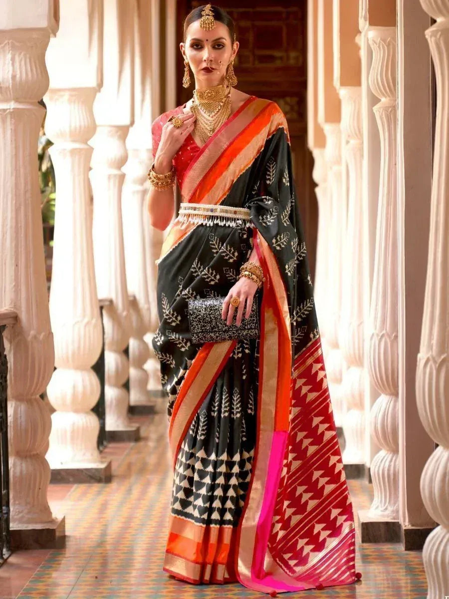 Black and red ethnic saree with gold embroidery, worn with traditional jewelry in palace corridor