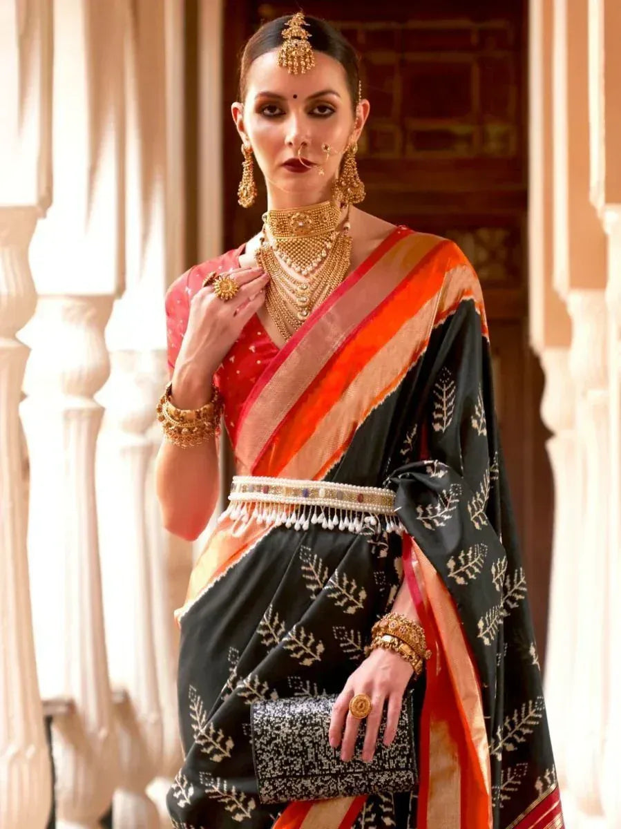Elegant black and red ethnic saree with gold embroidery, paired with traditional jewelry for festive occasions