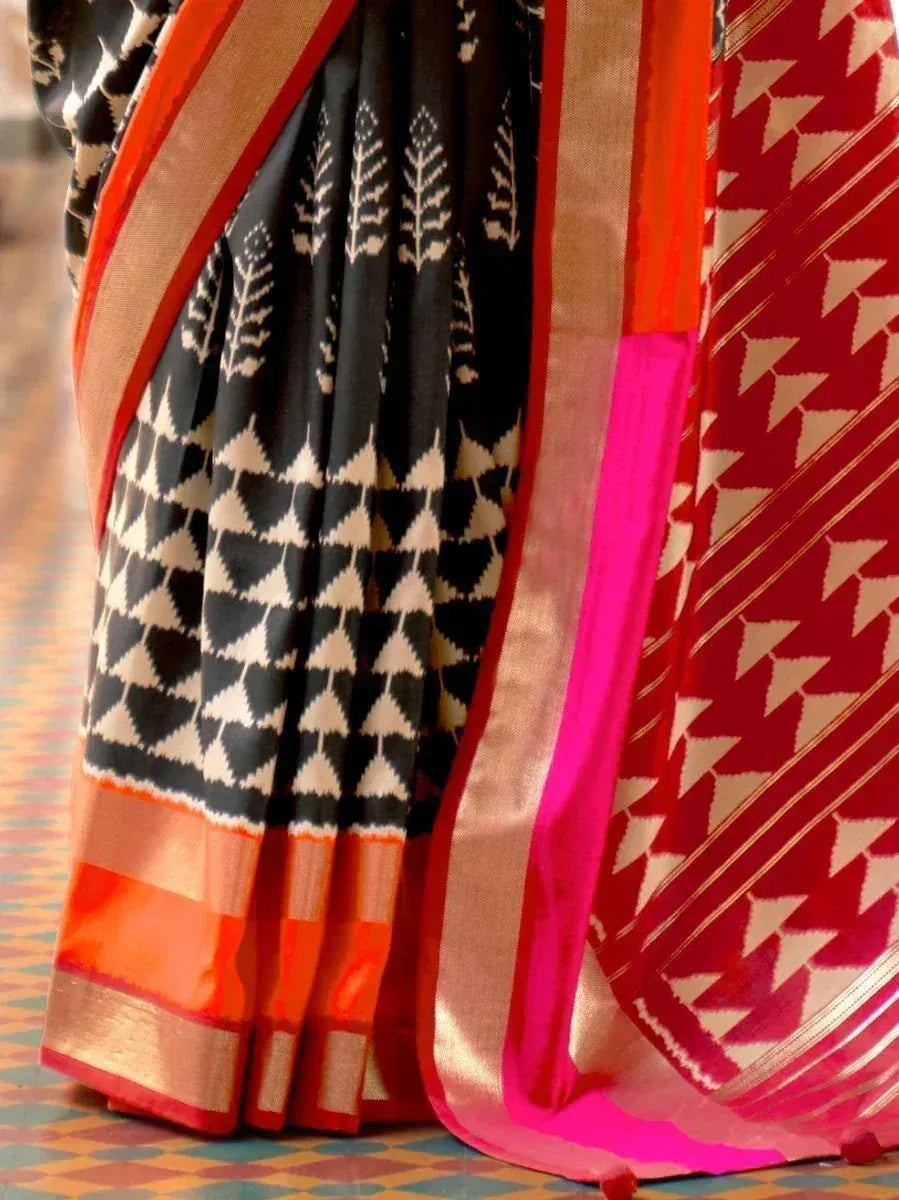 Black and red ikat saree with geometric patterns and vibrant border, ethnic Indian wear