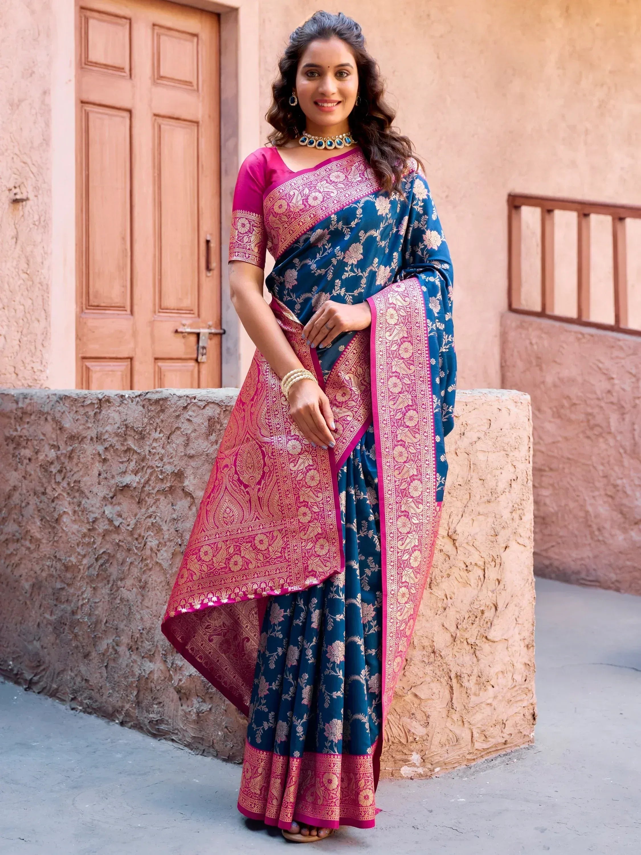 Woman in blue and pink floral saree with gold border, traditional Indian ethnic wear