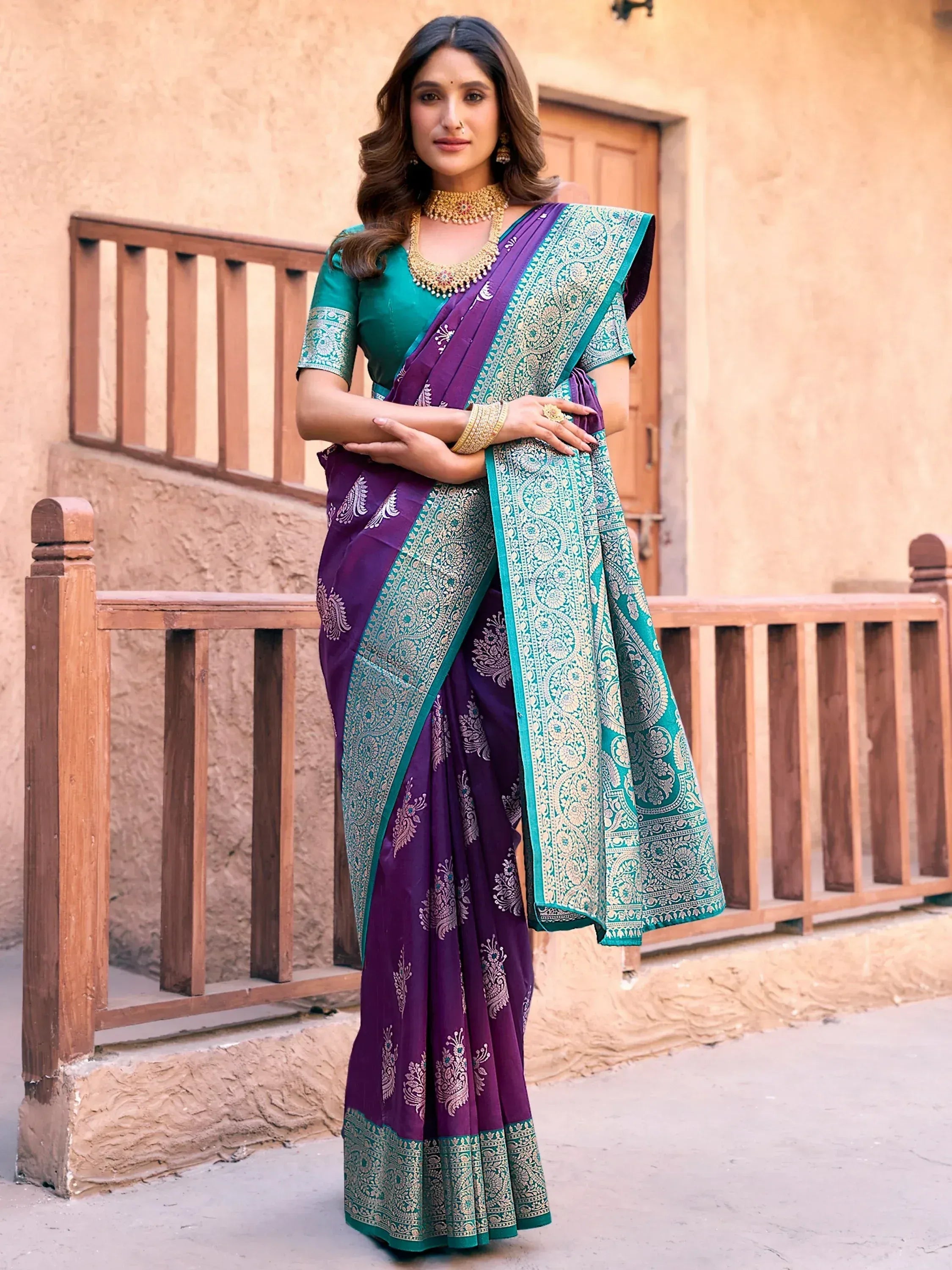 Woman in purple and teal designer saree with gold embroidery, traditional Indian ethnic wear