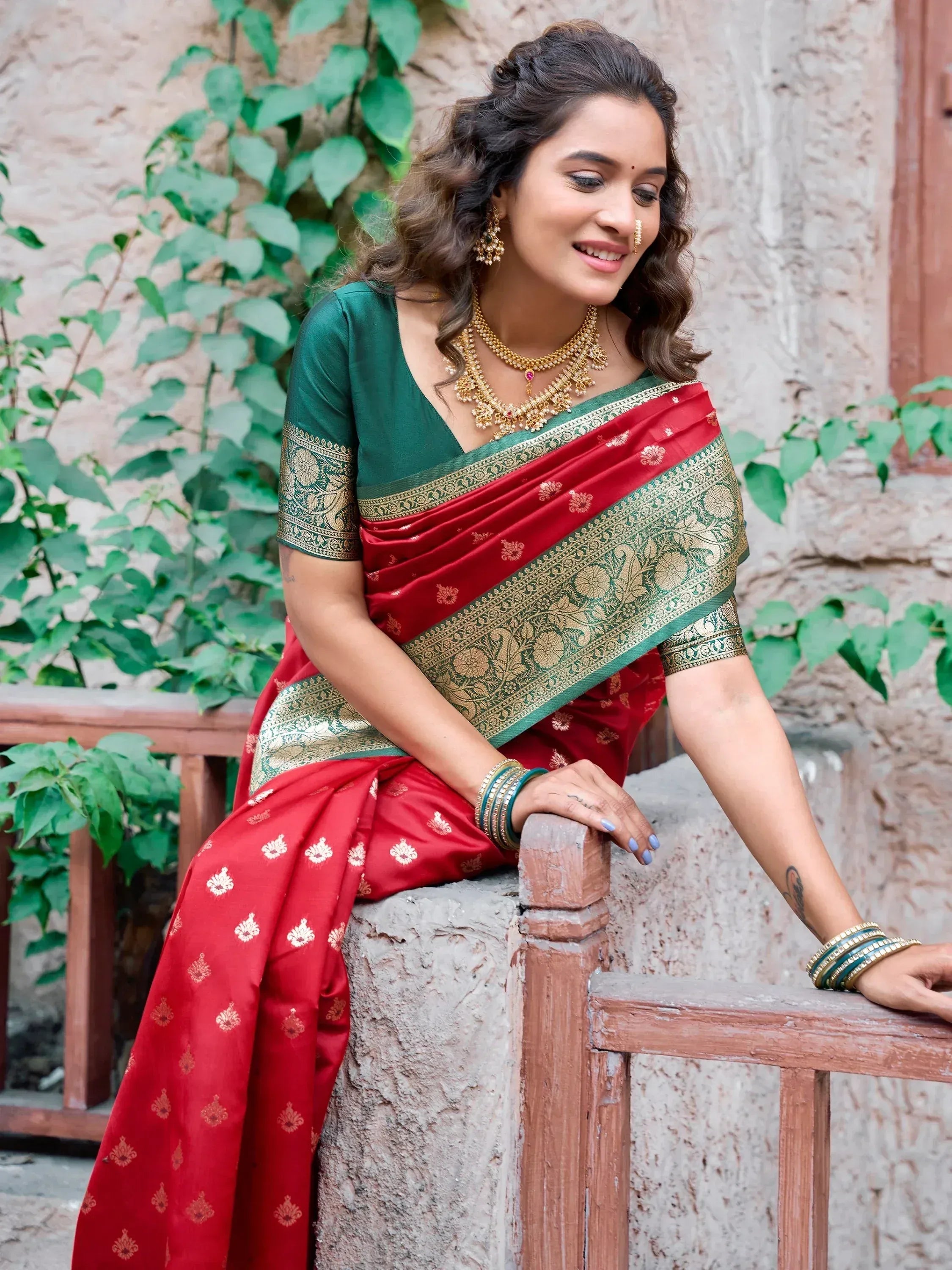 Woman in red and green designer saree with gold embroidery, traditional Indian ethnic wear