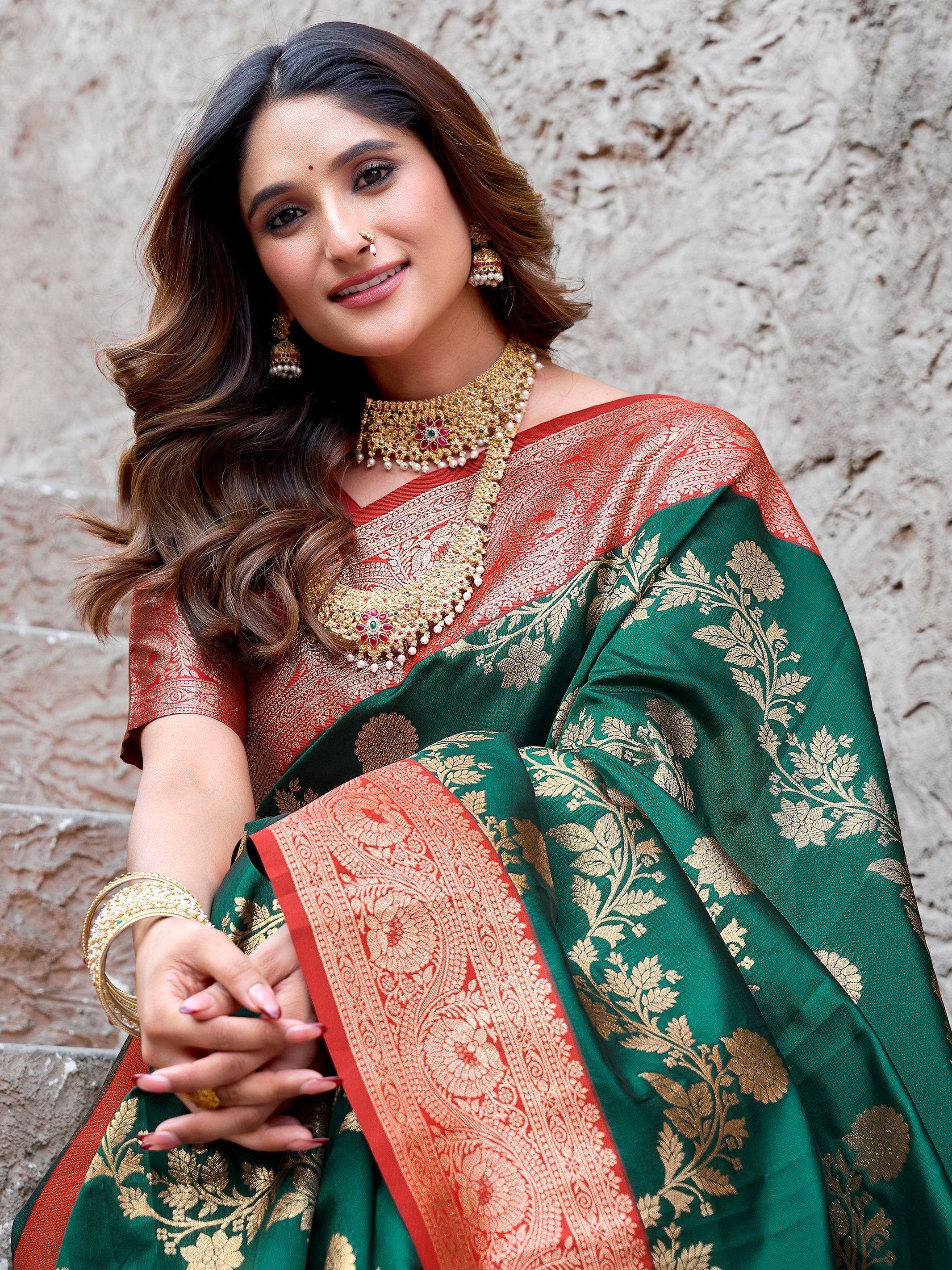 Woman in green and red designer saree with gold floral embroidery and traditional jewelry