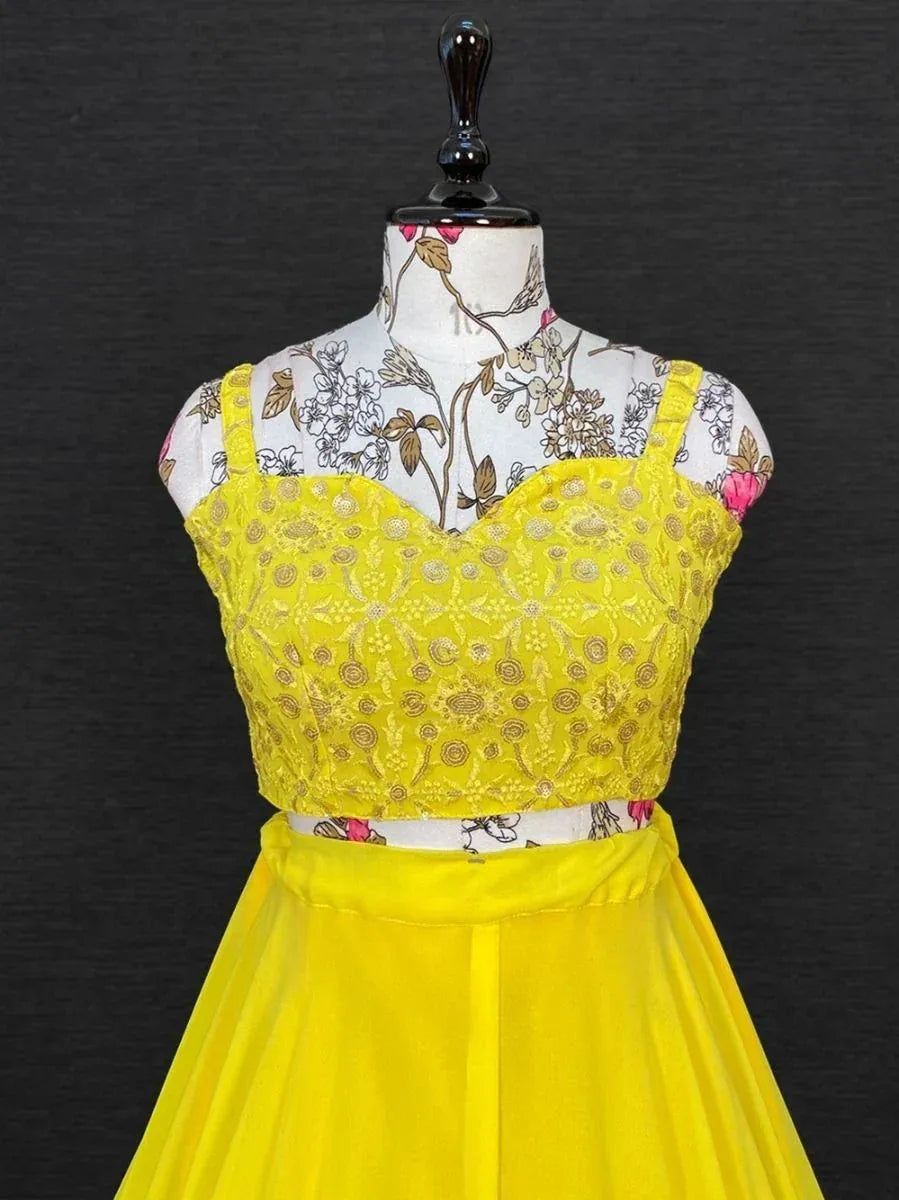 Bright yellow ethnic gown with floral lace top and pleated skirt, perfect for Indian festive occasions.