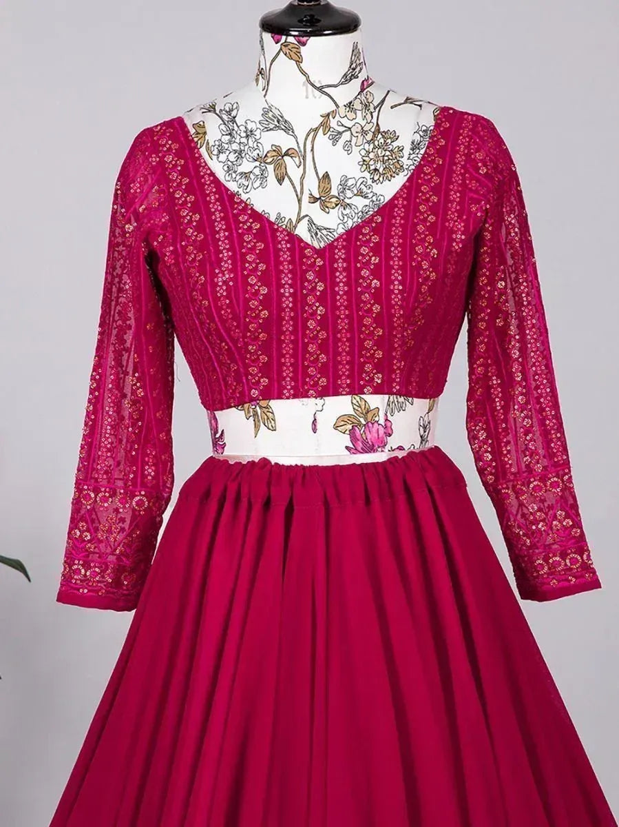 Fuchsia ethnic gown with floral embroidery and sheer sleeves, perfect for Indian celebrations