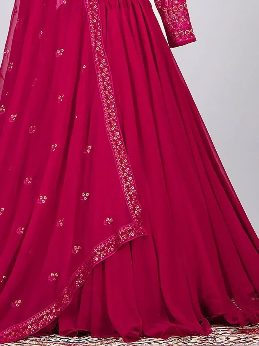 Fuchsia ethnic gown with gold embroidery and sheer dupatta, perfect for Indian festive occasions