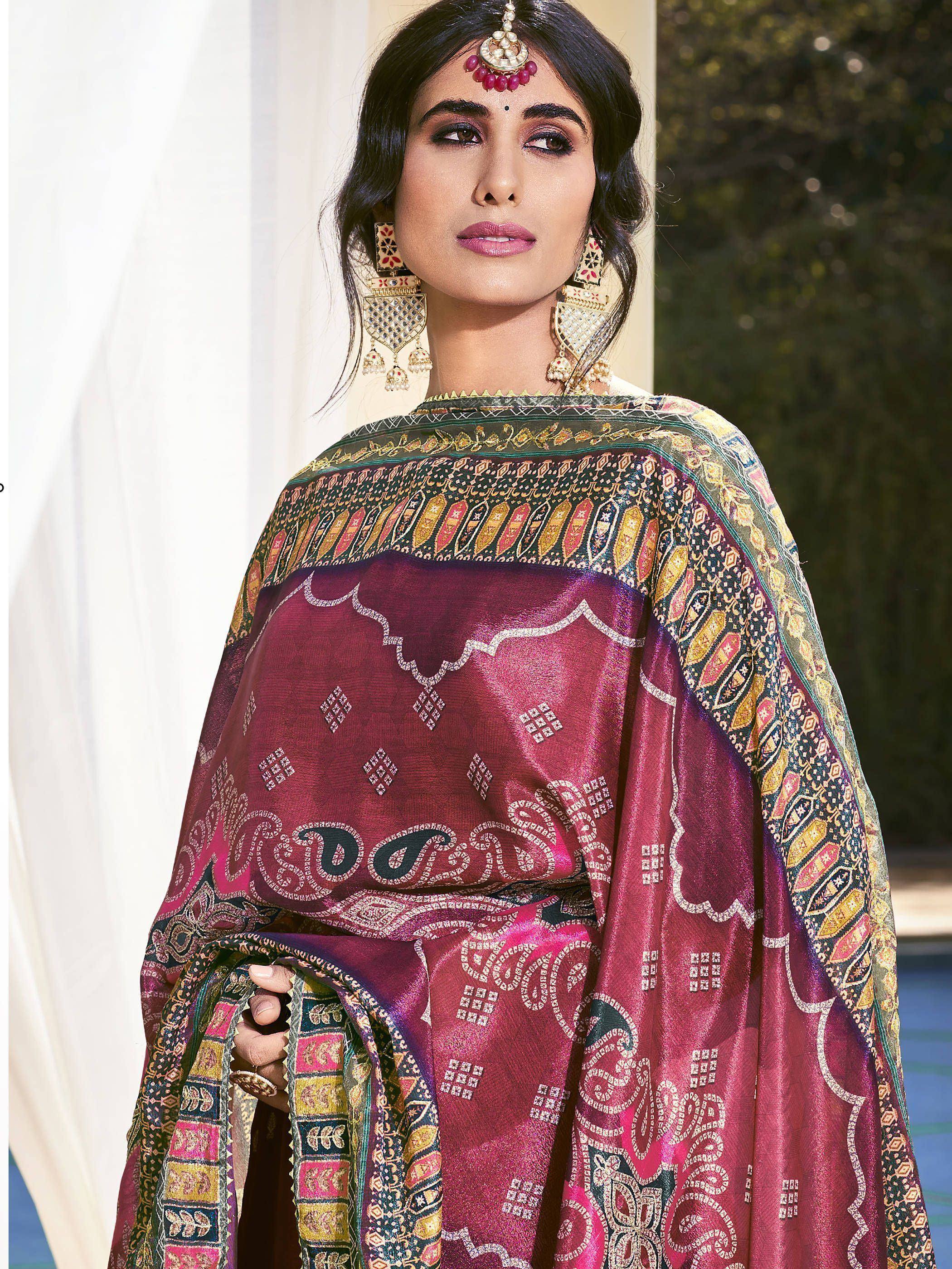 Woman in maroon ethnic salwar kameez with intricate gold embroidery and traditional jewelry