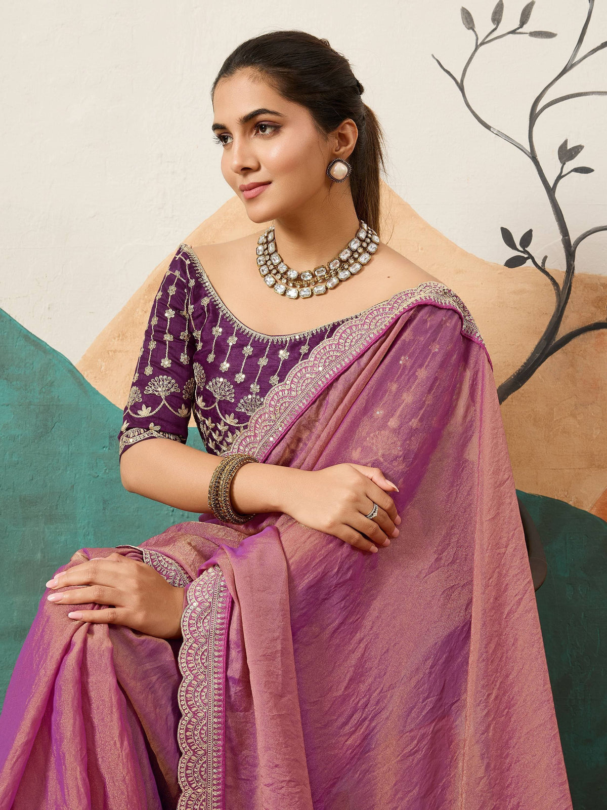 Purple embroidered saree with gold detailing, paired with statement jewelry for ethnic wear
