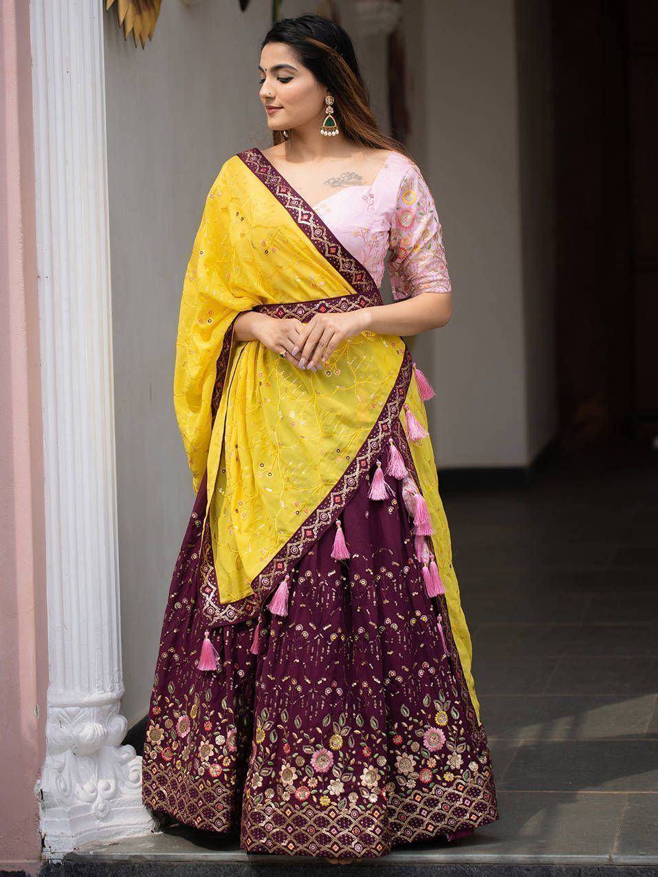Yellow and maroon embroidered lehenga choli with pink tassels, perfect for Indian ethnic occasions