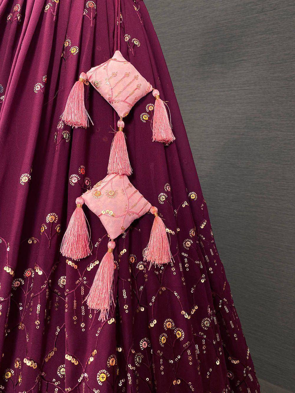 Purple lehenga with pink tassel embellishments and floral embroidery, ideal for Indian ethnic wear