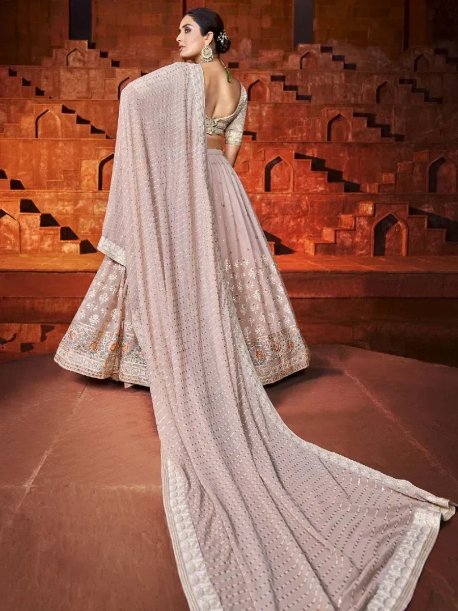 Elegant beige lehenga choli with intricate embroidery and long dupatta, perfect for Indian weddings and festive occasions.