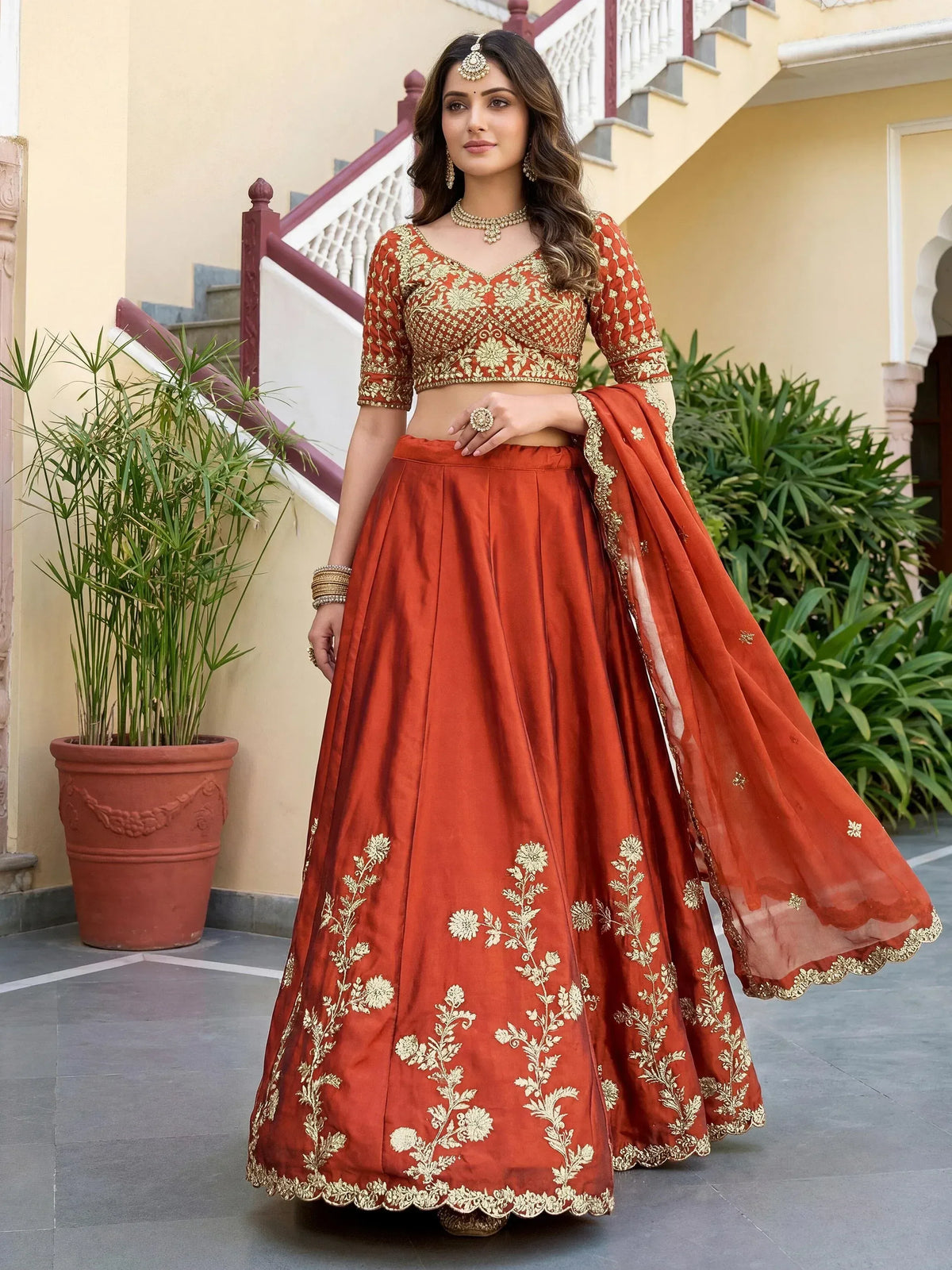 Elegant rust-colored lehenga choli with gold floral embroidery, perfect for Indian ethnic wear.