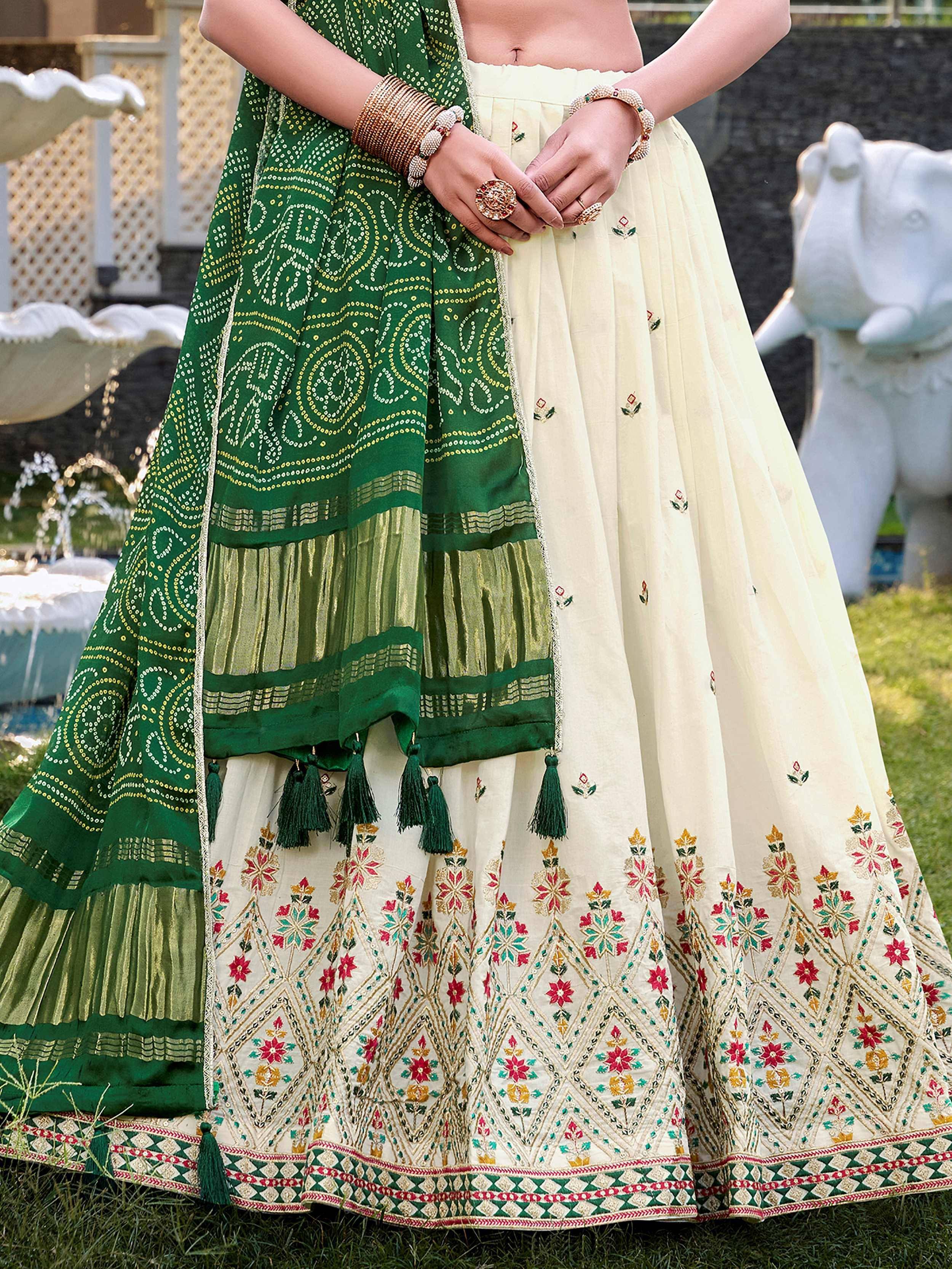 Cream embroidered lehenga with green dupatta, floral motifs, tassels, perfect for Indian ethnic wear occasions