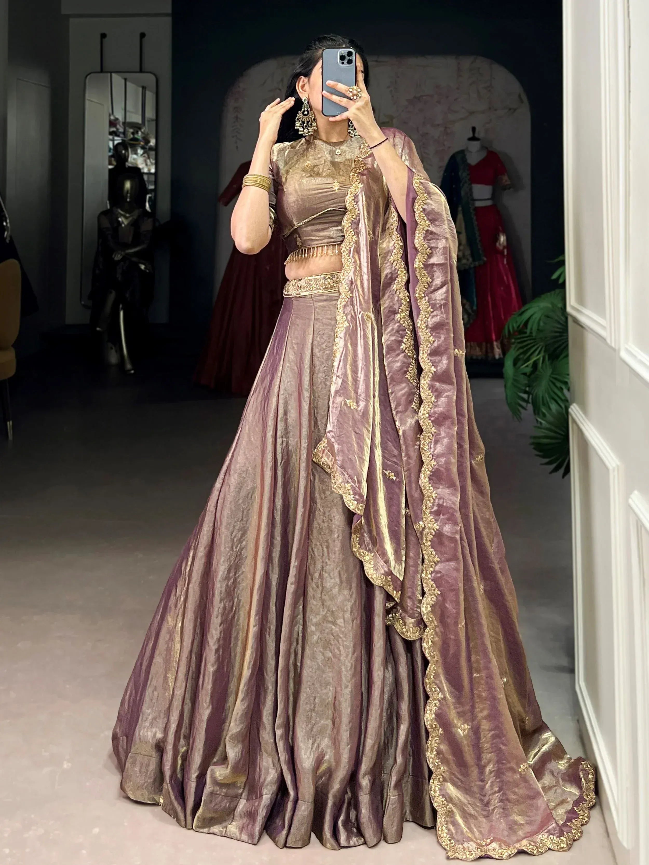 Woman in purple gold embroidered lehenga choli taking mirror selfie, Indian ethnic wear