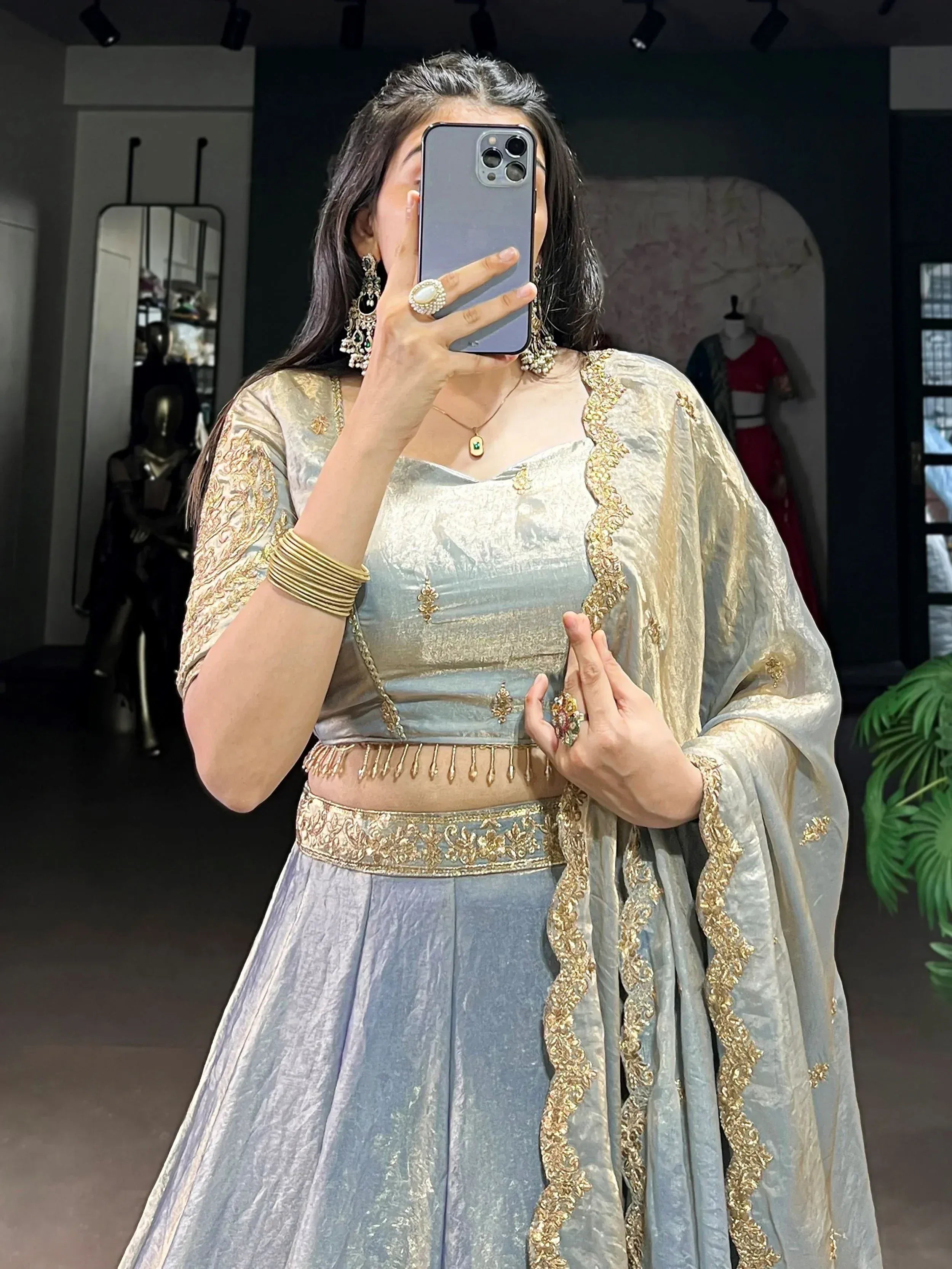 Woman in elegant light blue lehenga choli with gold embroidery, perfect for Indian ethnic wear occasions.