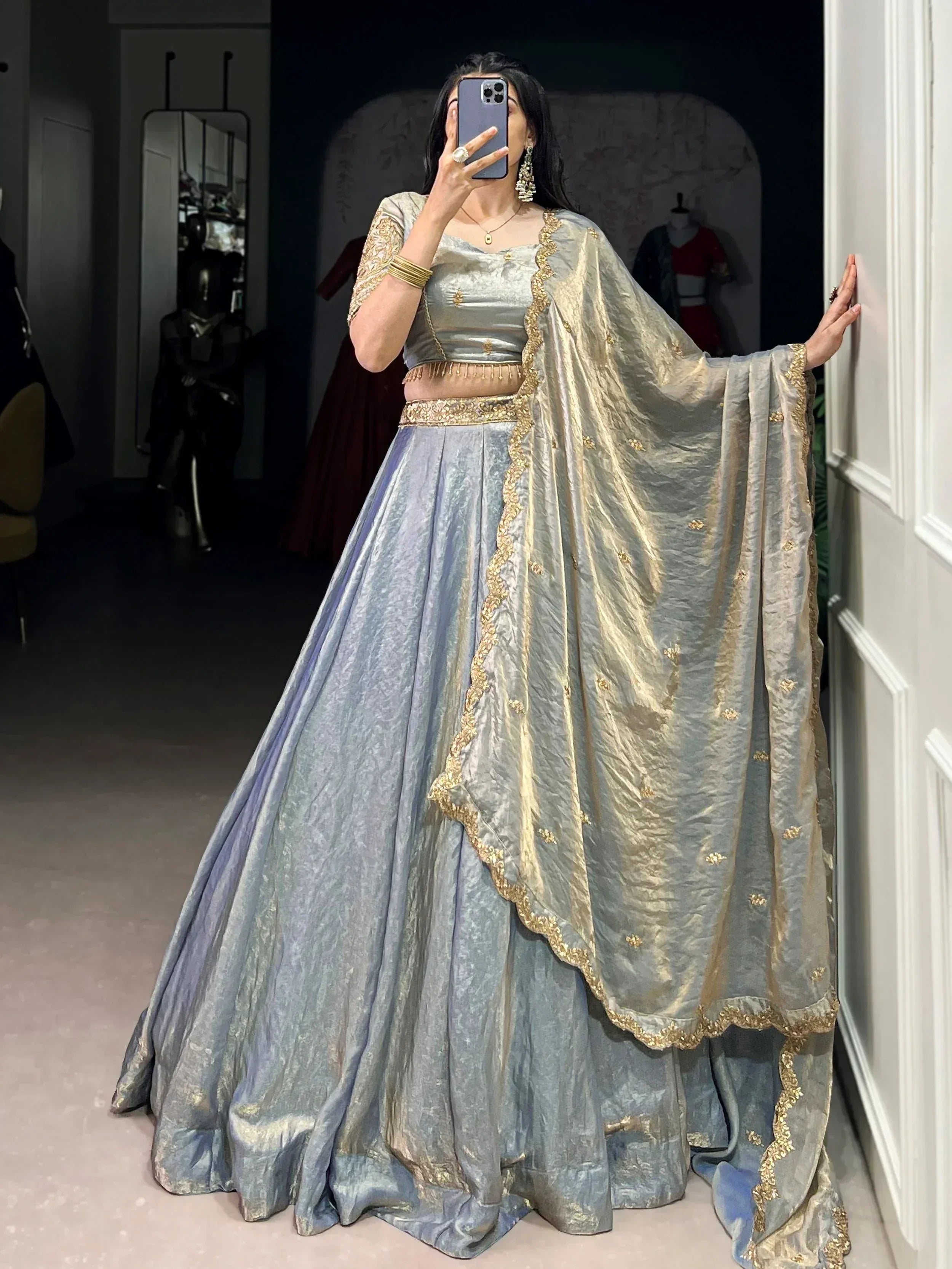 Elegant silver-grey lehenga choli with gold embroidery, perfect for Indian ethnic wear occasions.