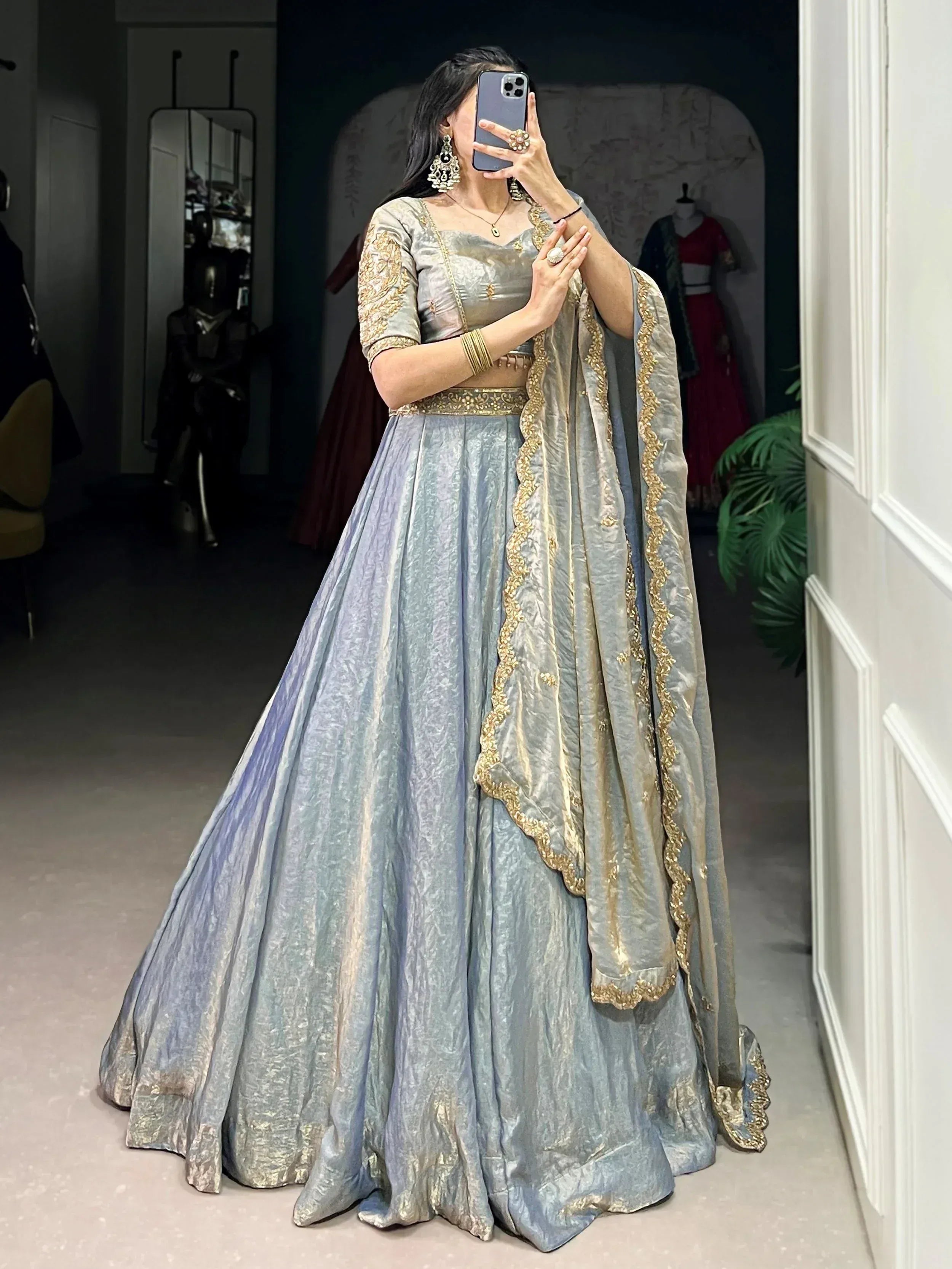 Elegant silver-grey lehenga choli with gold embroidery, perfect for Indian weddings and festive occasions.