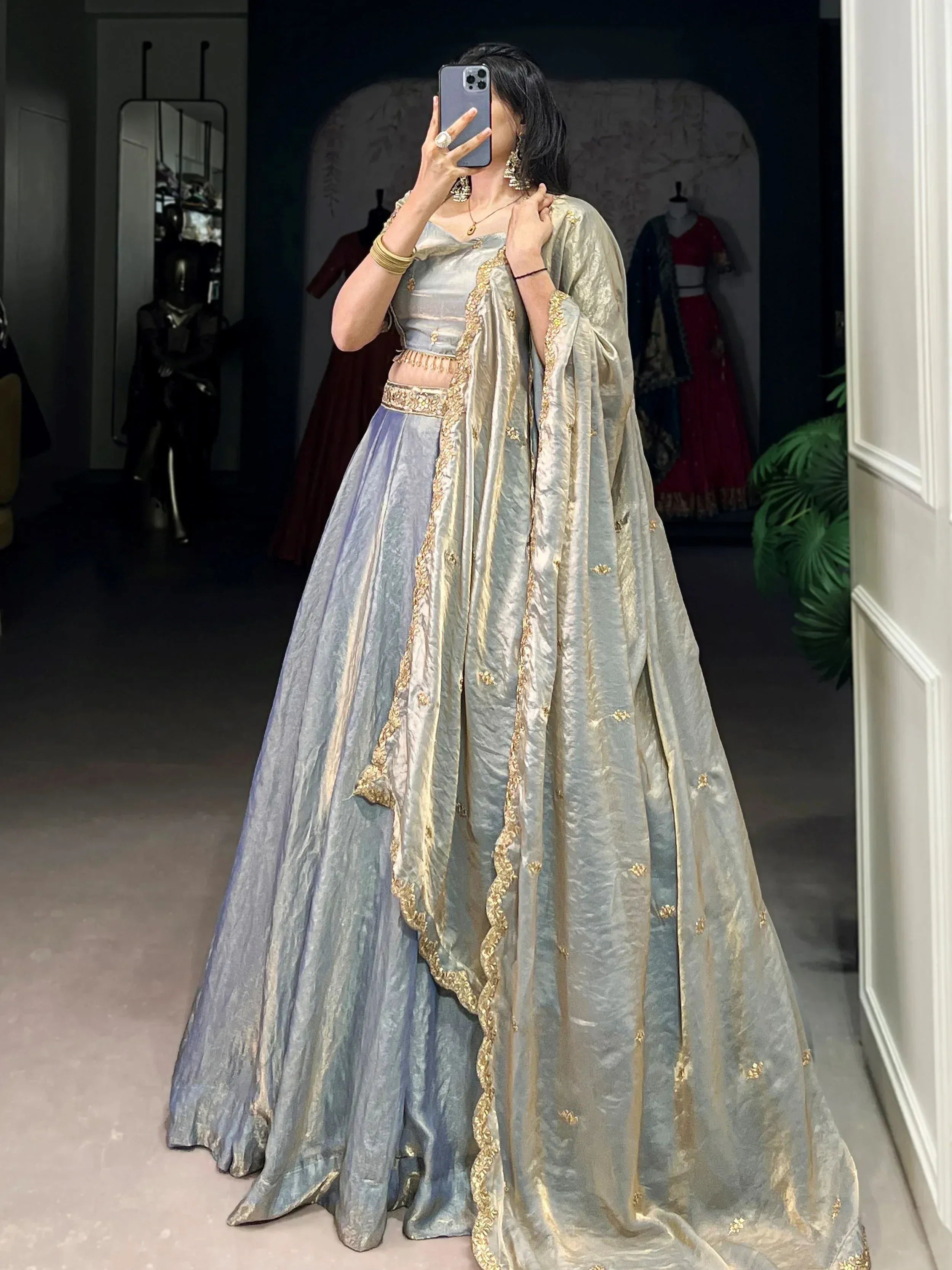 Elegant silver-grey lehenga choli with gold embroidery, perfect for Indian weddings and festive occasions.