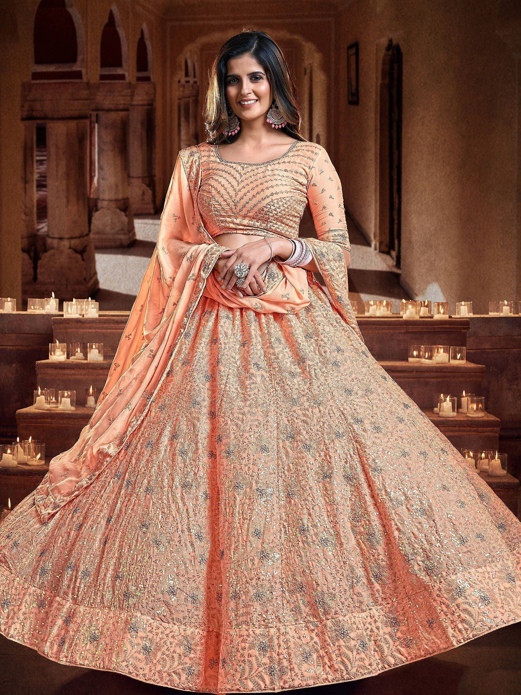 Peach designer lehenga choli with intricate embroidery, perfect for Indian weddings and festive occasions.